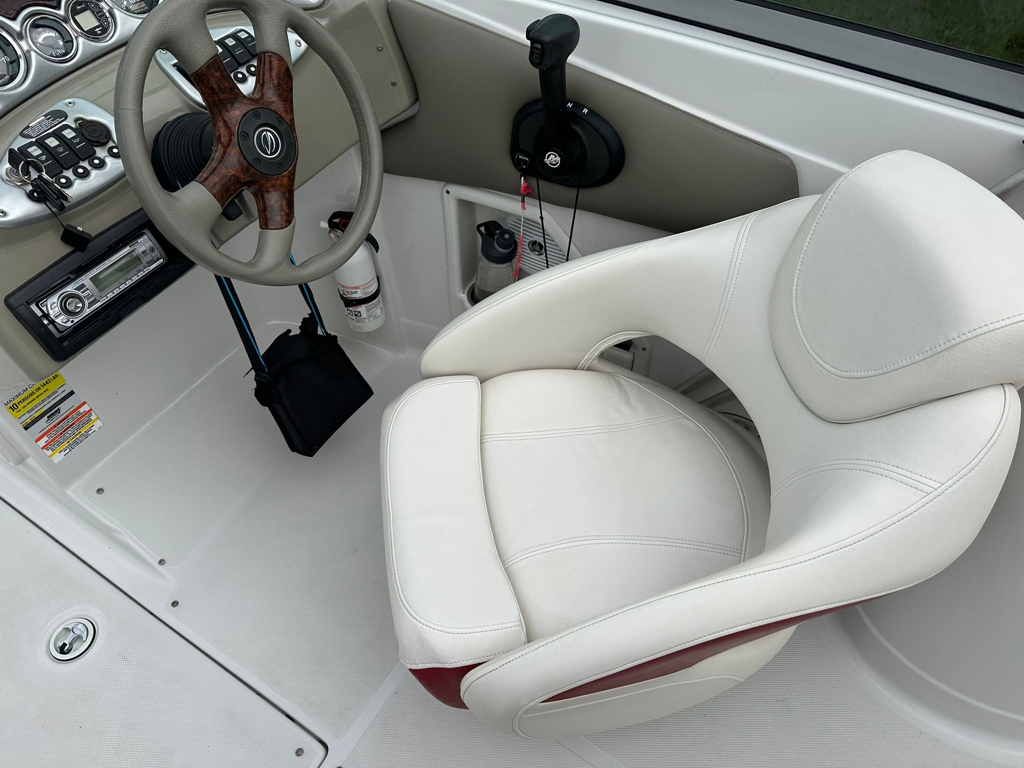 Interior of a 2009 Crownline 220 EX boat with a white seat and wood steering wheel.