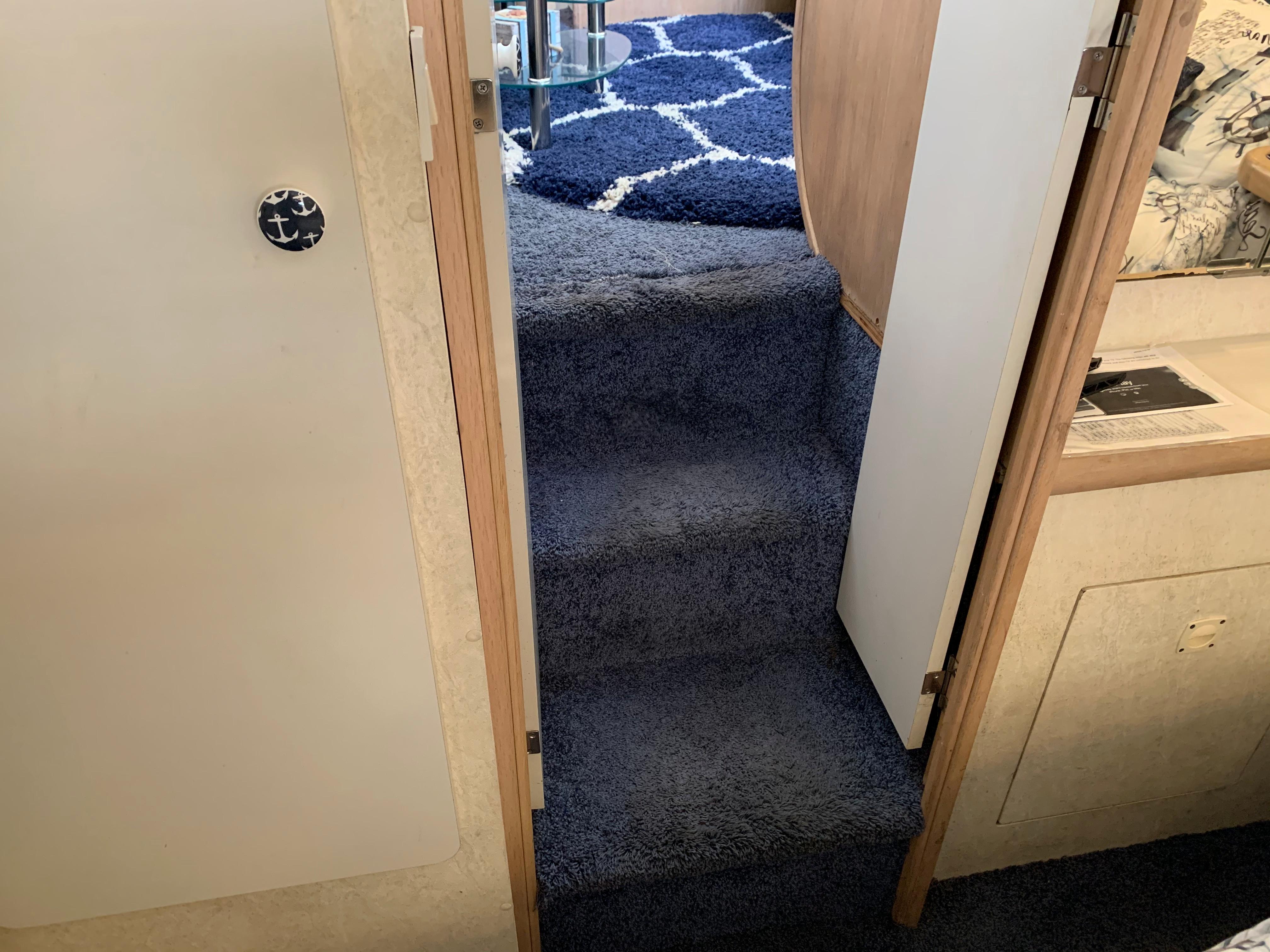 Interior stairs of 1992 Silverton 34 Aft Cabin Motor Yacht with blue carpet.