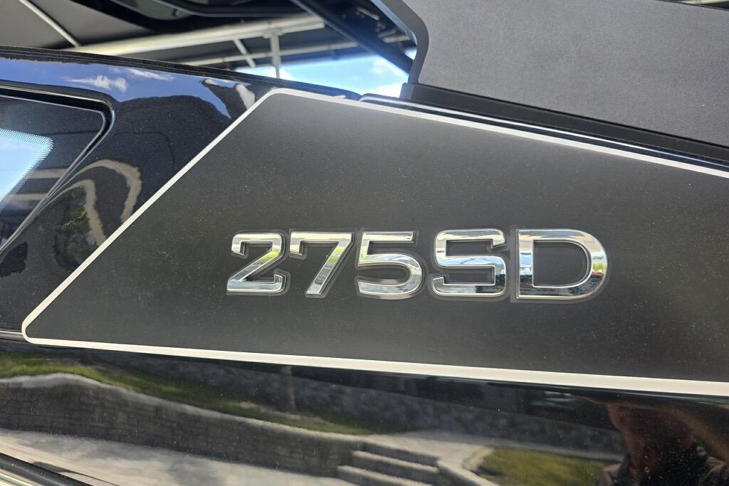 Close-up of 2025 Yamaha Boats 275SD model emblem on sleek black surface.