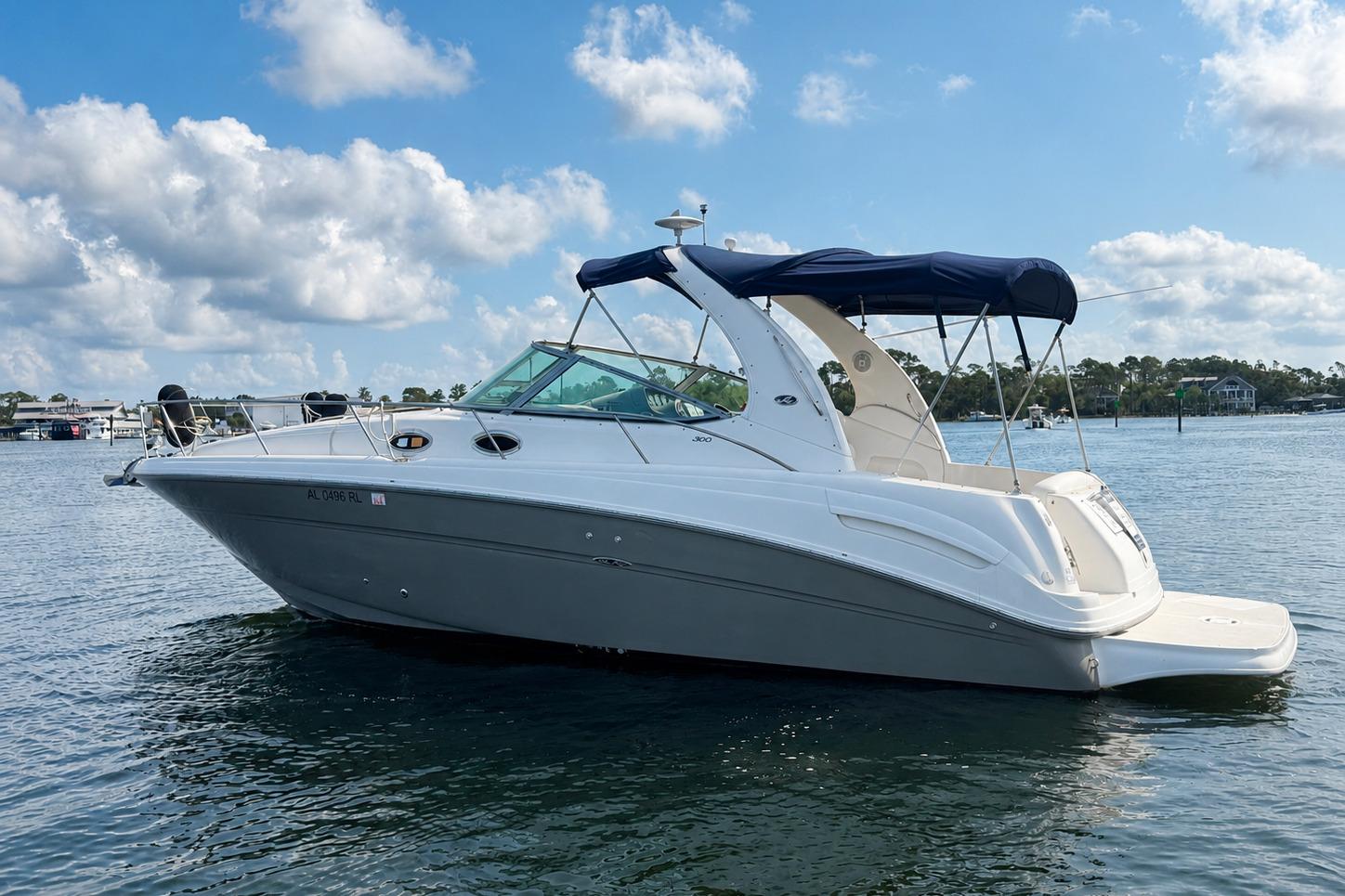 2006 Sea Ray 300 Sundancer boat on calm water under a blue sky.