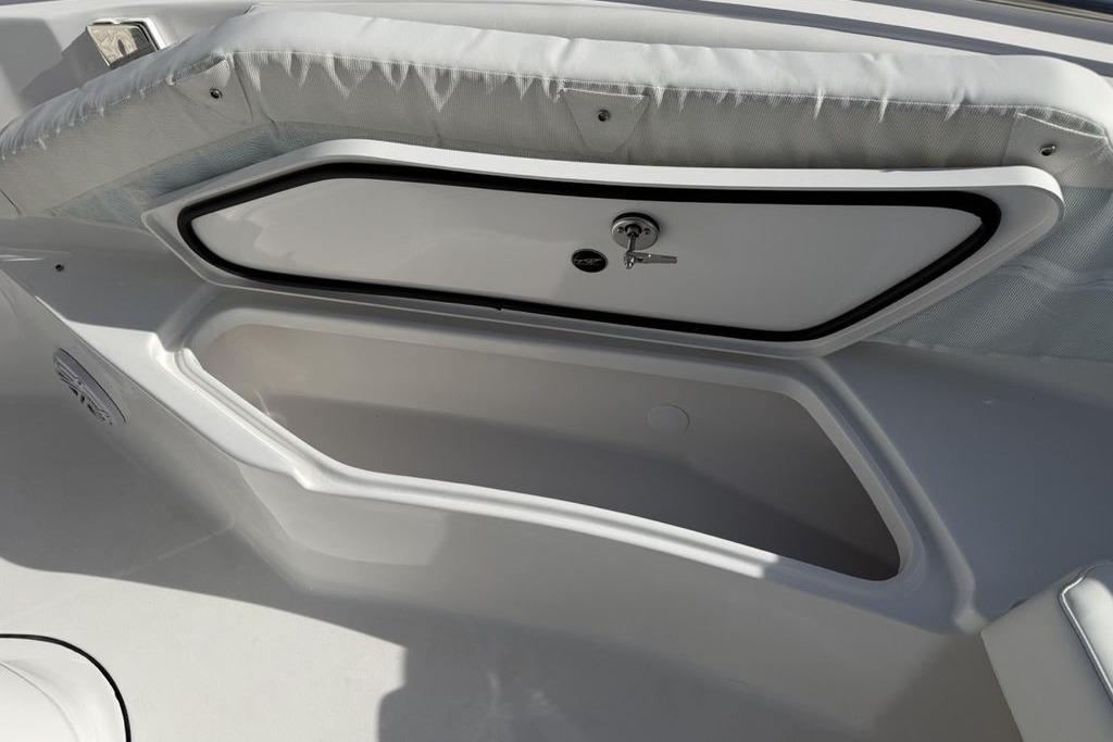 Storage compartment on 2026 Tidewater 232 LXF boat, featuring secure lock and cushioned seating.