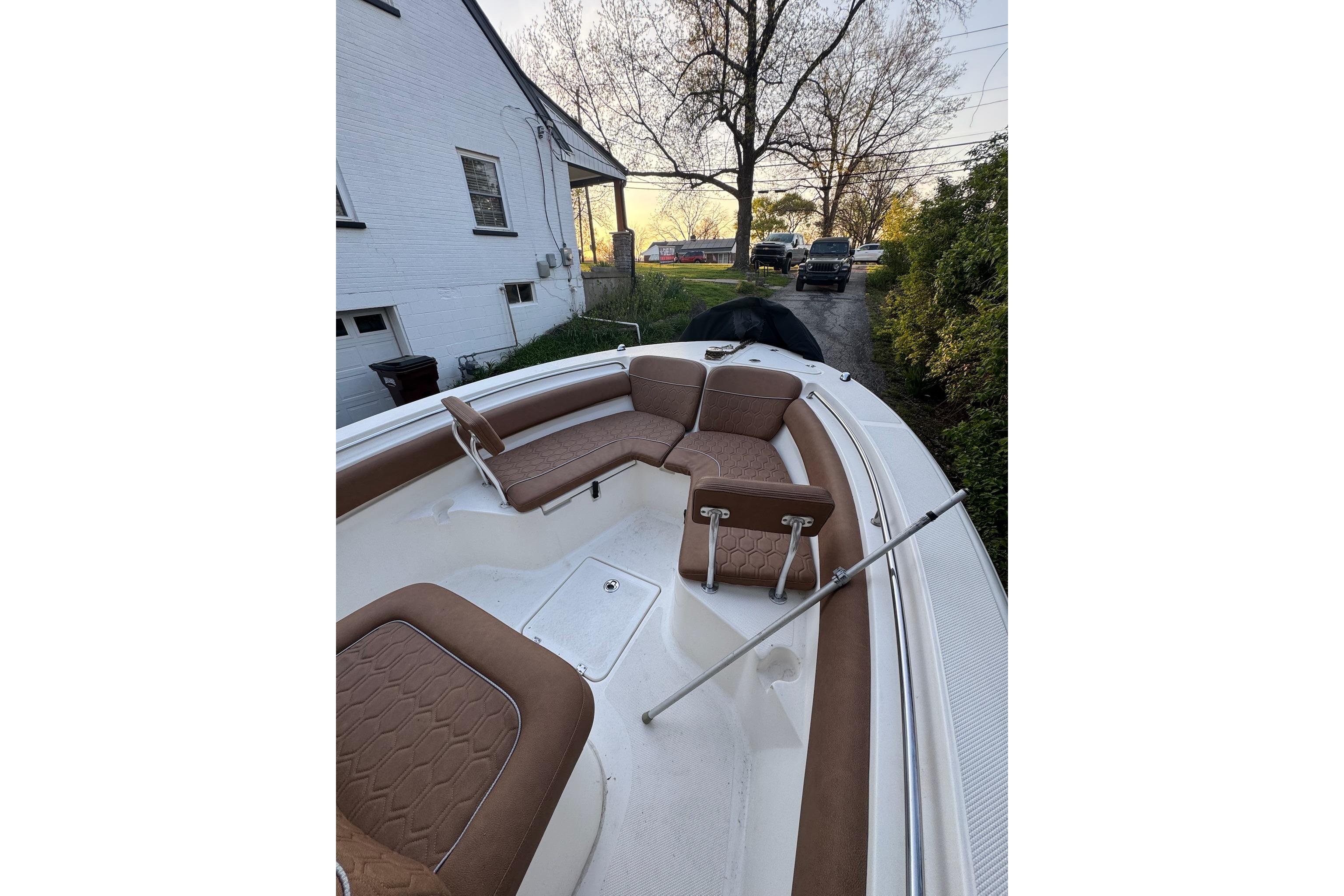 2013 Sea Fox 246 Commander boat with brown seating, parked near a white house.