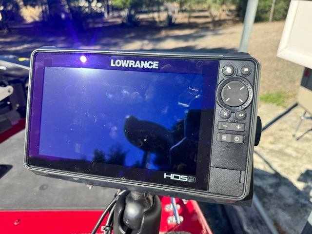 A Lowrance HDS display is mounted on a boat, surrounded by red decking.