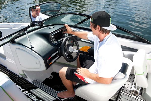 Manufacturer Provided Image: Man operating 2013 Nautique Super Air Nautique 230 boat on water.