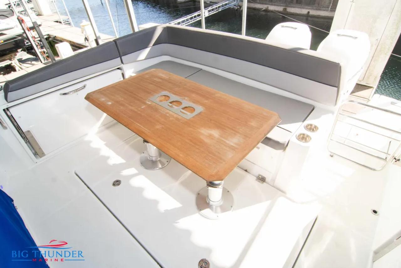 2020 Jeanneau Leader 10.5 boat deck with wooden table and seating area.