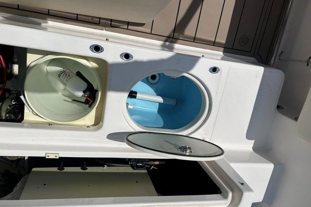 2017 Robalo R200ES boat storage compartments with fire extinguisher and open hatch.