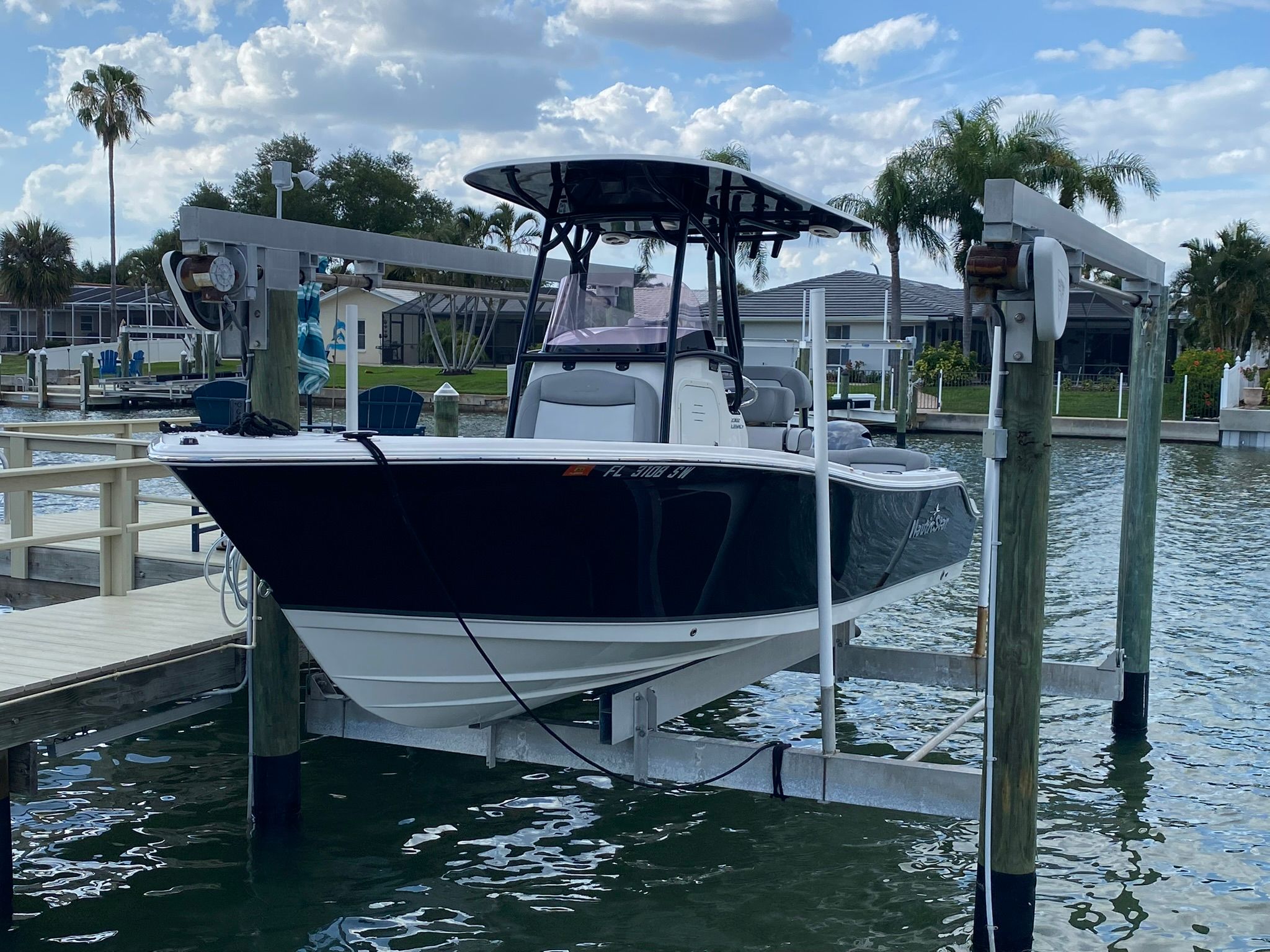 2021 NauticStar Legacy boat on a lift by the water.