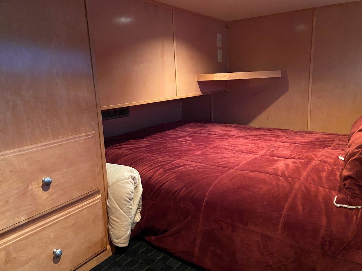 Bedroom in Summersun Houseboats 16x68, 2006 model, with red bedding.