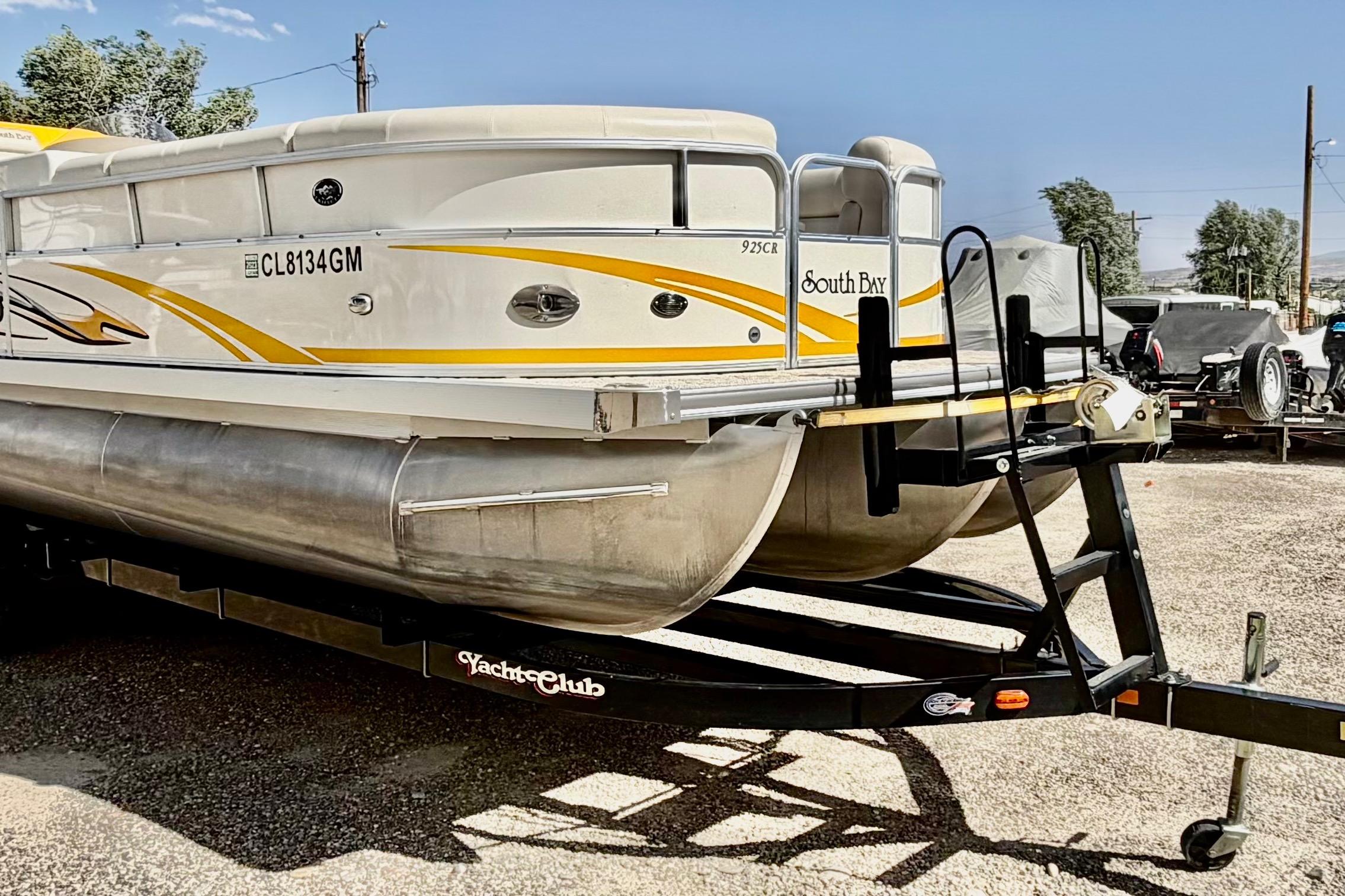 2006 South Bay 925CR pontoon boat on trailer, featuring yellow accents and sturdy design.