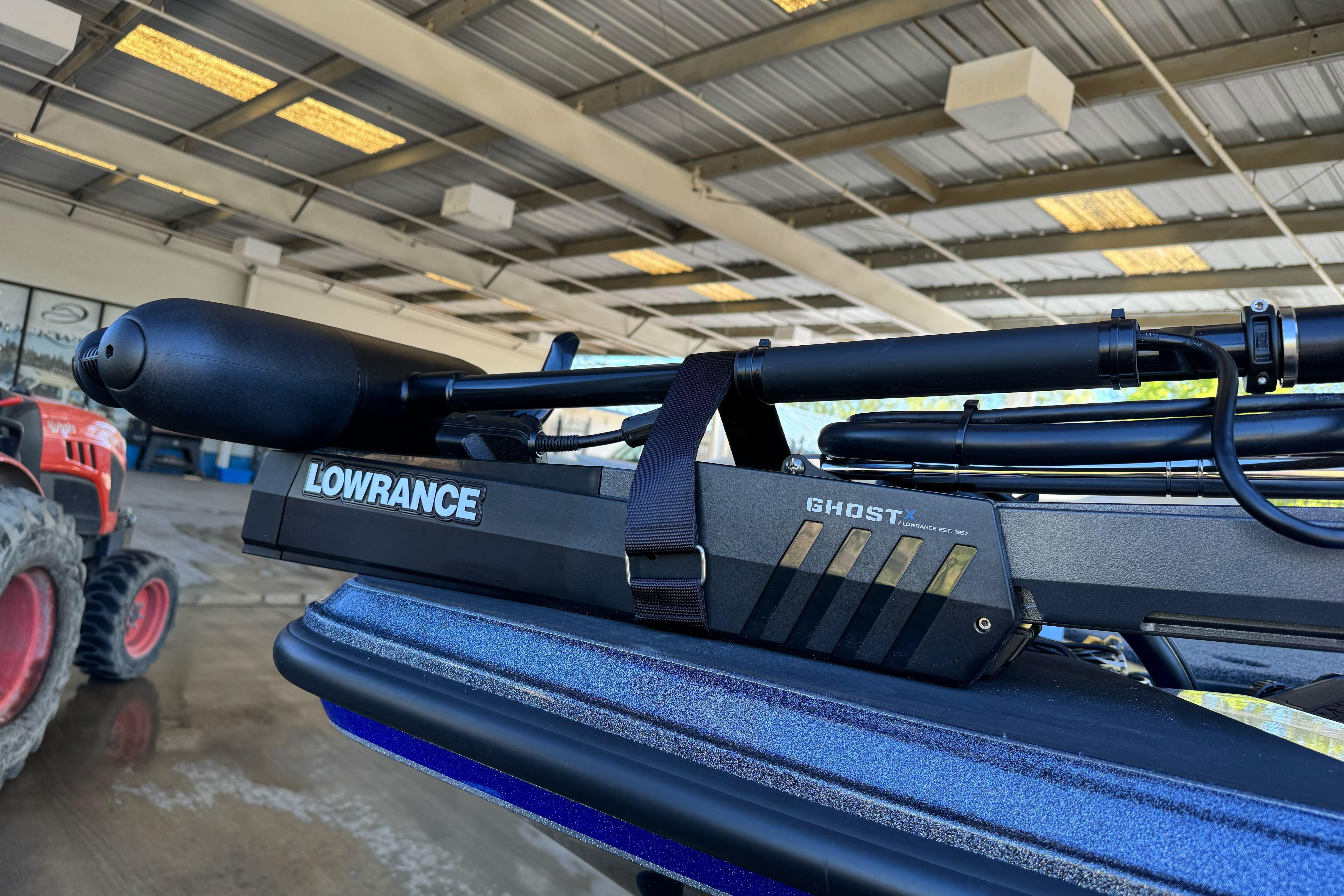 Triton 21XP Patriot 2026 with Lowrance Ghost trolling motor in a garage setting.