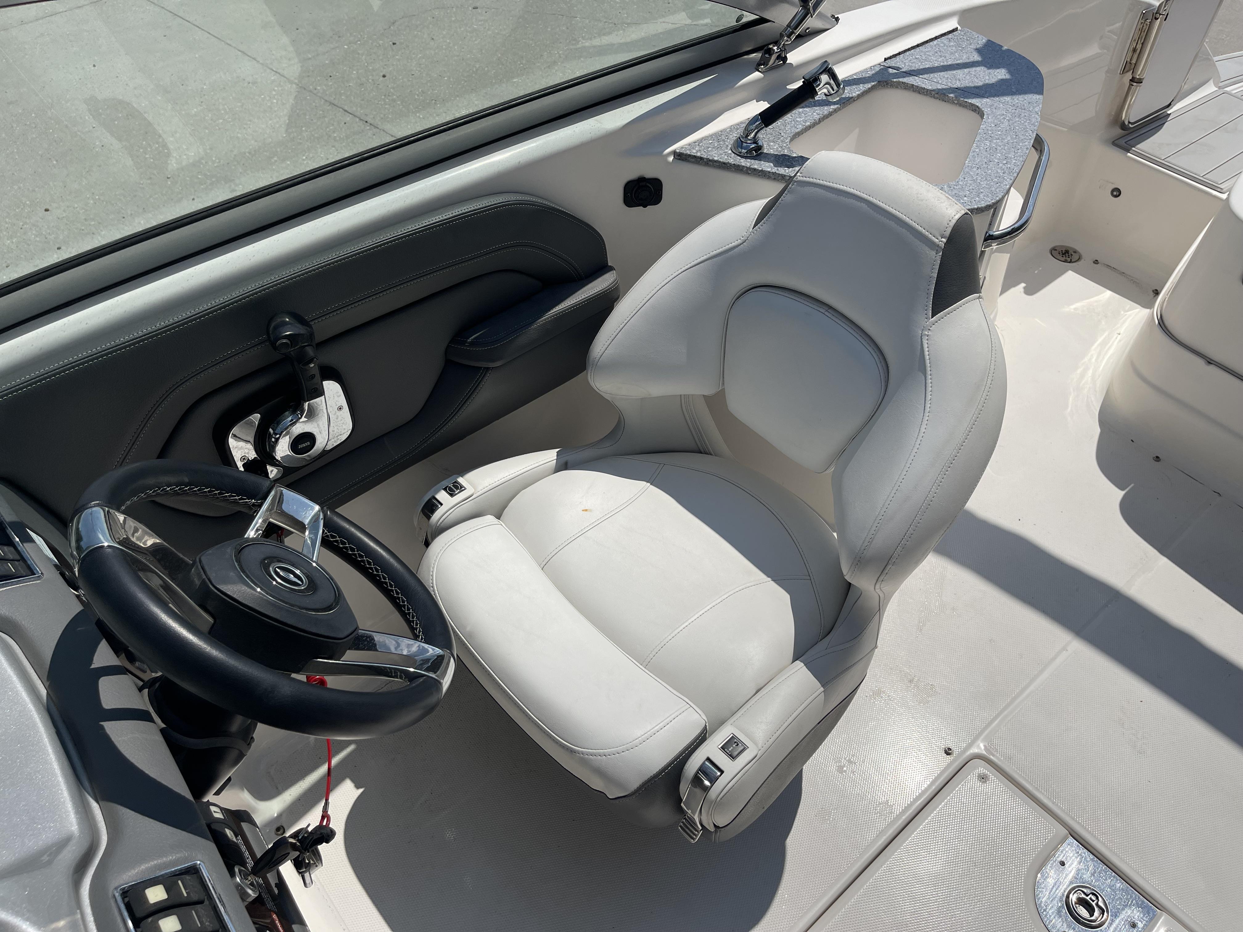 2014 Chaparral Sunesta 224 boat interior with steering wheel and captain's seat.