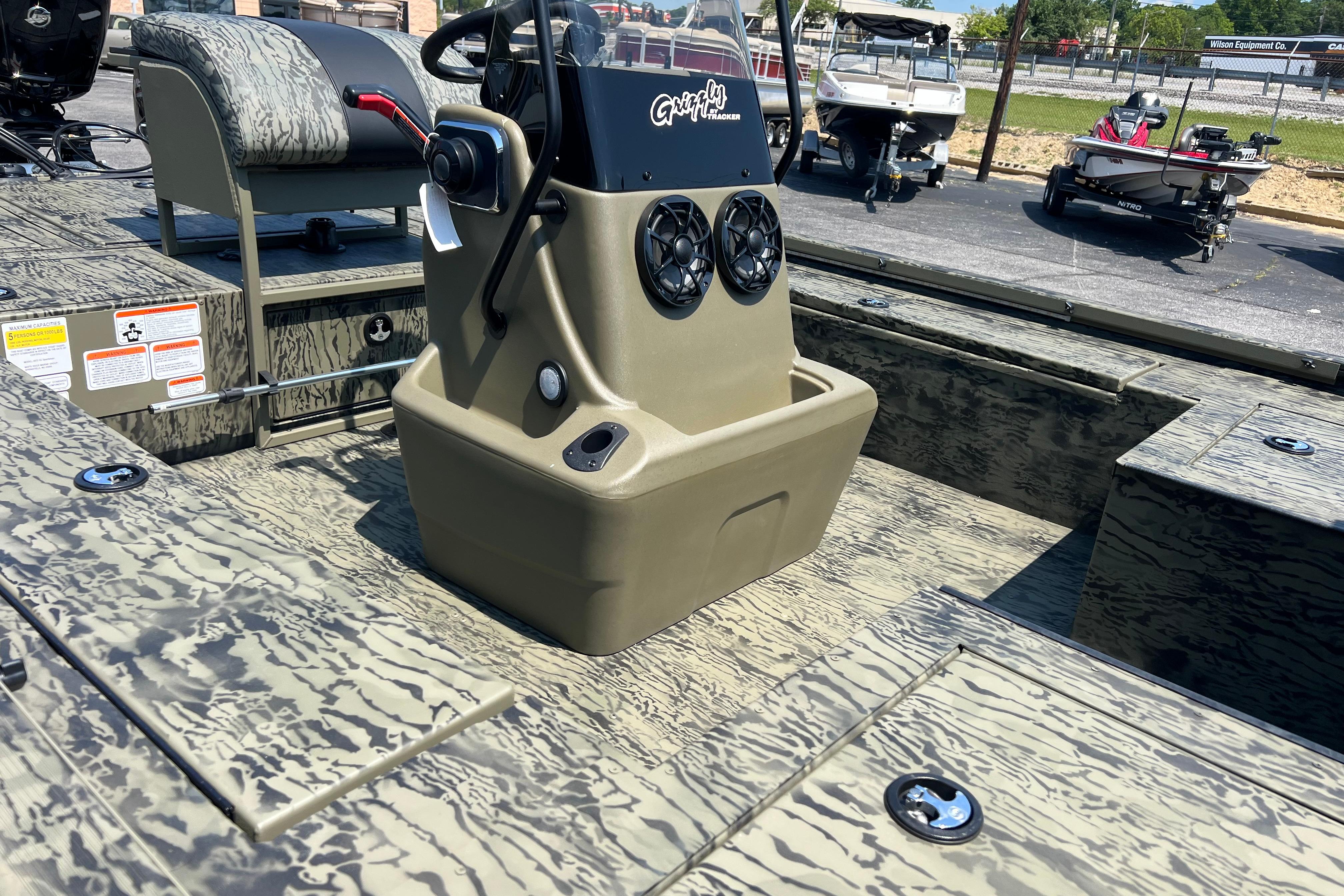 2026 Tracker Grizzly 2072 CC Sportsman Kicker boat interior with camouflage design and control console.