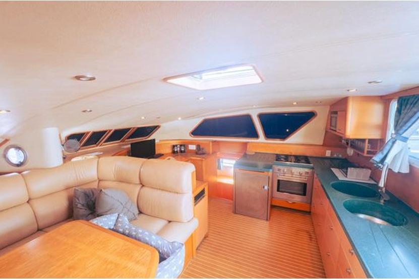 Luxurious yacht interior with modern kitchen and seating, 2005 Custom Luxury Performance model.