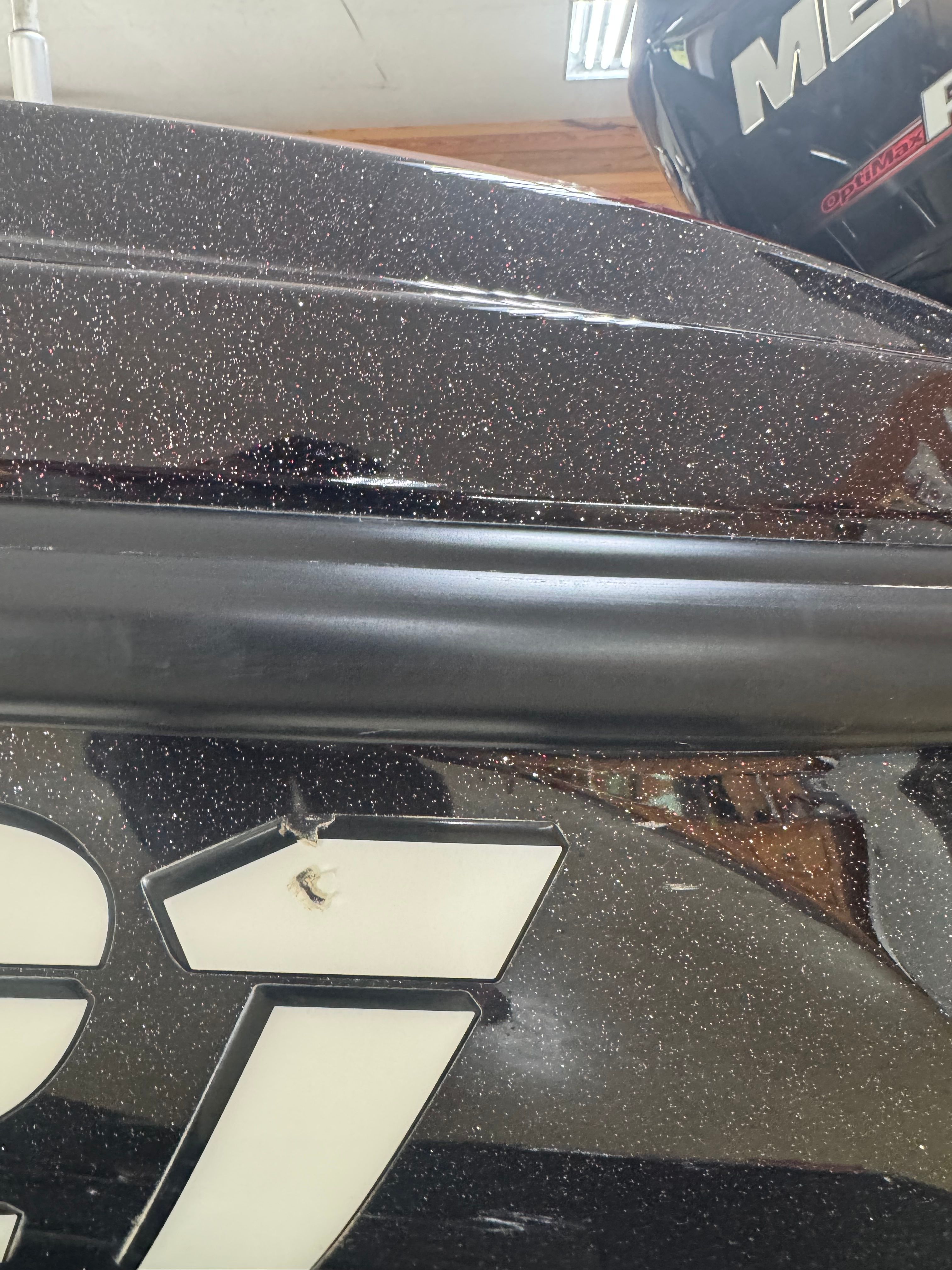 Close-up of a boat hull with a glitter effect and a small scratch.