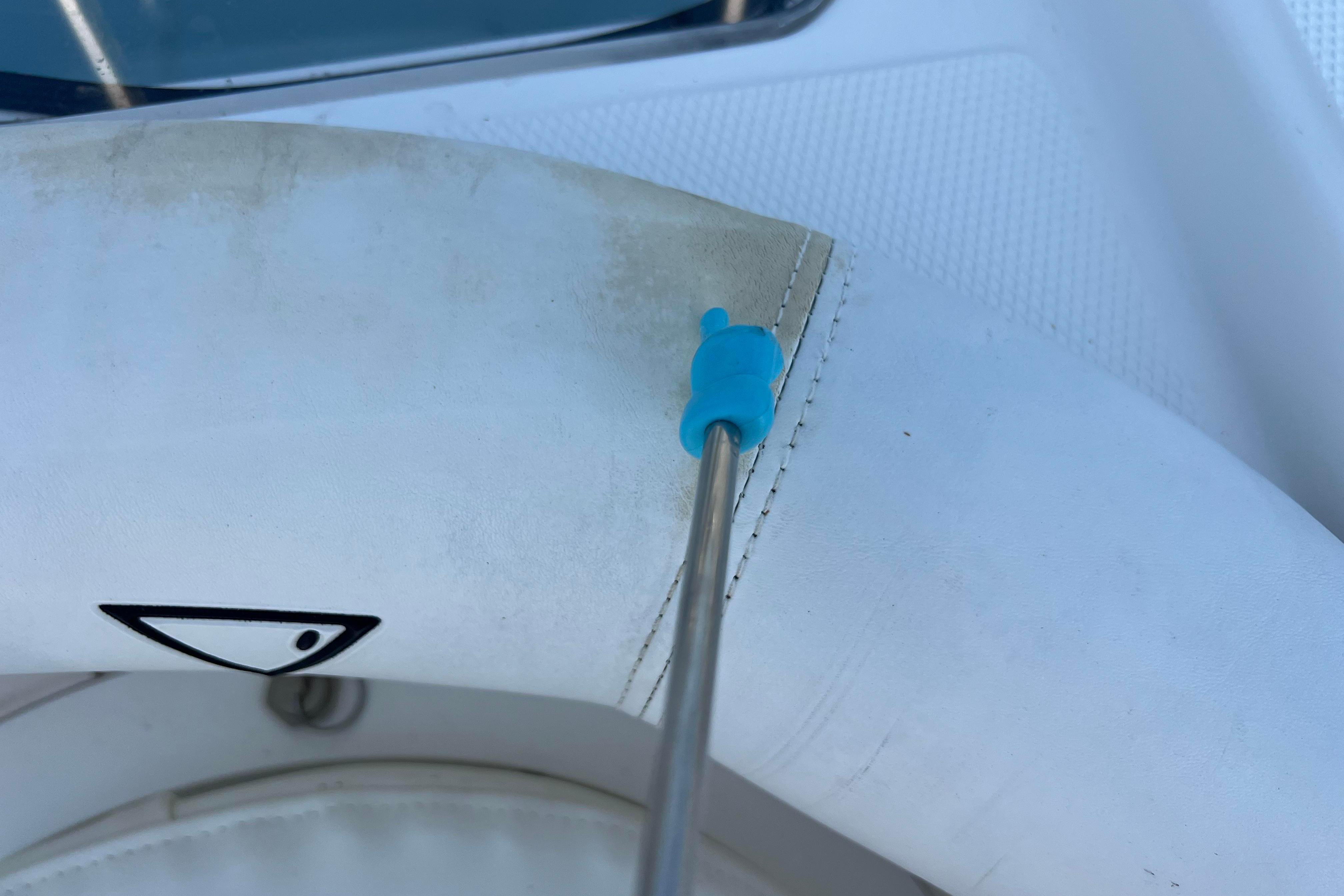 Close-up of a 2012 Sea Fox 206 Center Console boat's steering wheel with a blue tool.