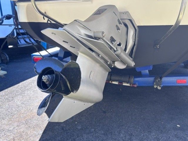 Close-up of a boat motor with propeller, mounted on a trailer.