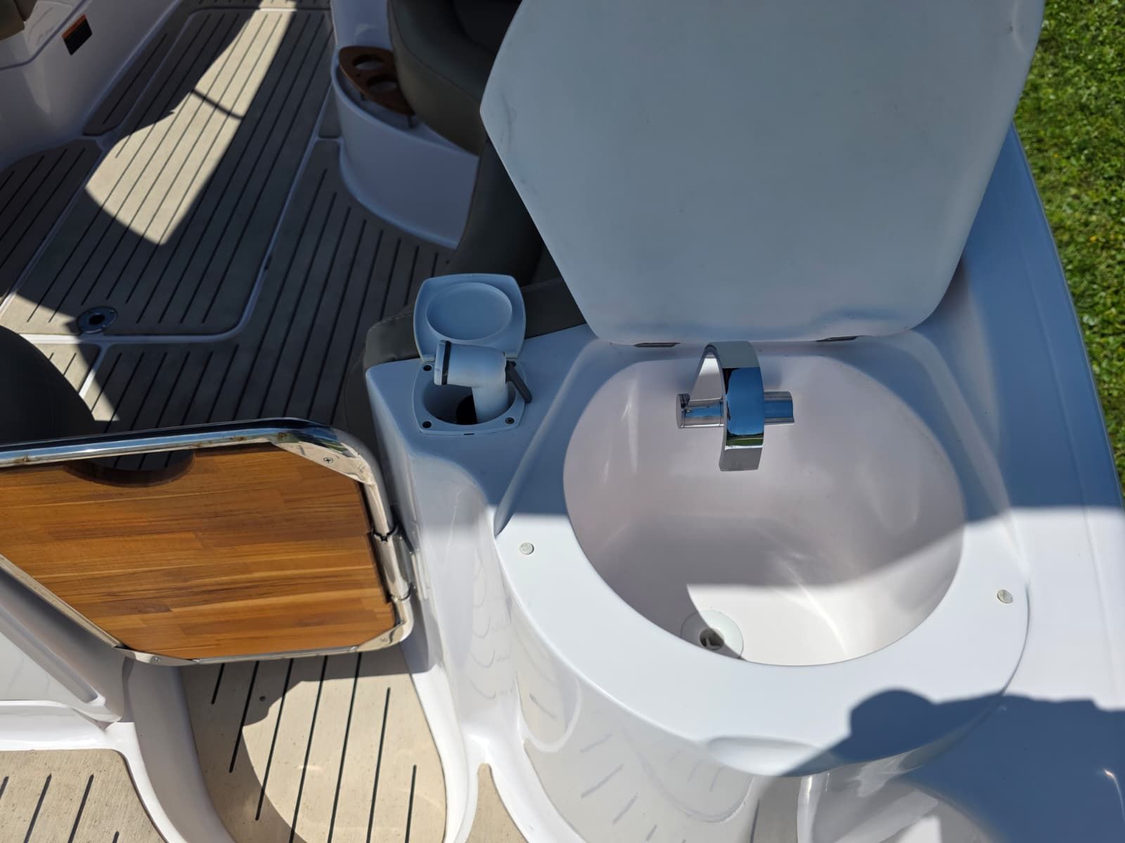 The image shows a sink on a boat with wooden details and a faucet.