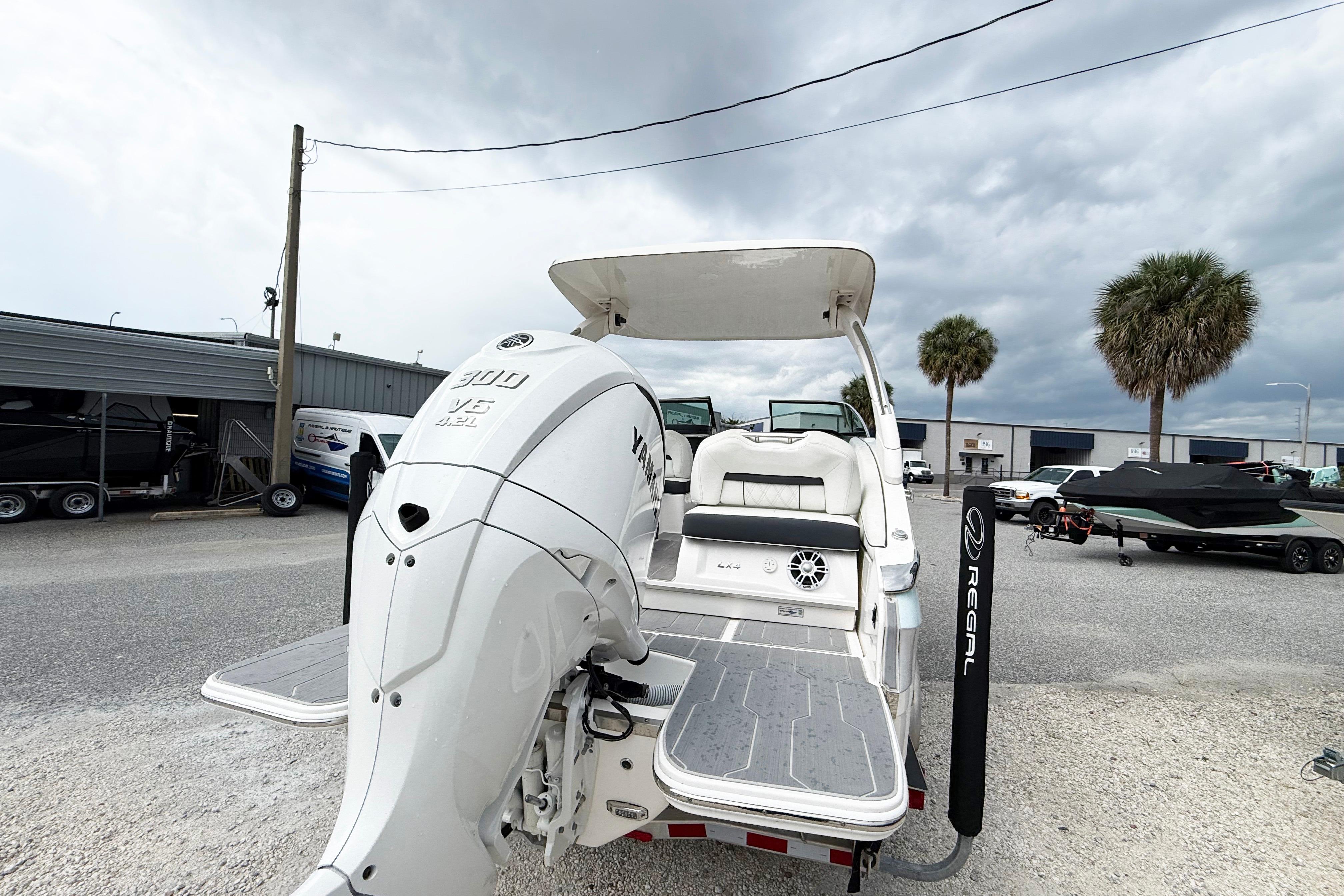2024 Regal LX4 boat with Yamaha 300 V6 engine, docked under cloudy skies.