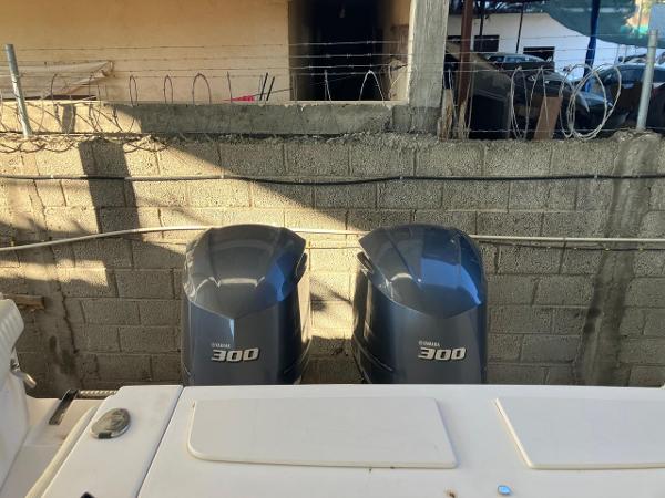 2006 Grady-White Bimini 306 with twin Yamaha 300 engines, docked near concrete wall.