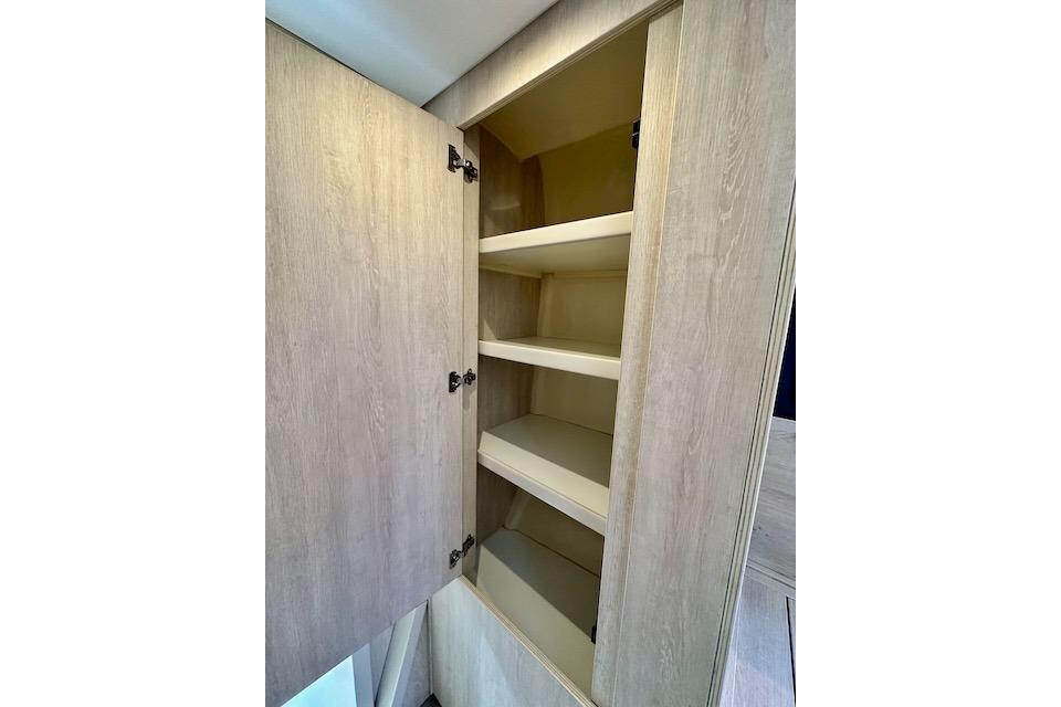 Wooden cabinet with open shelves inside a 2017 Leopard 40 model.