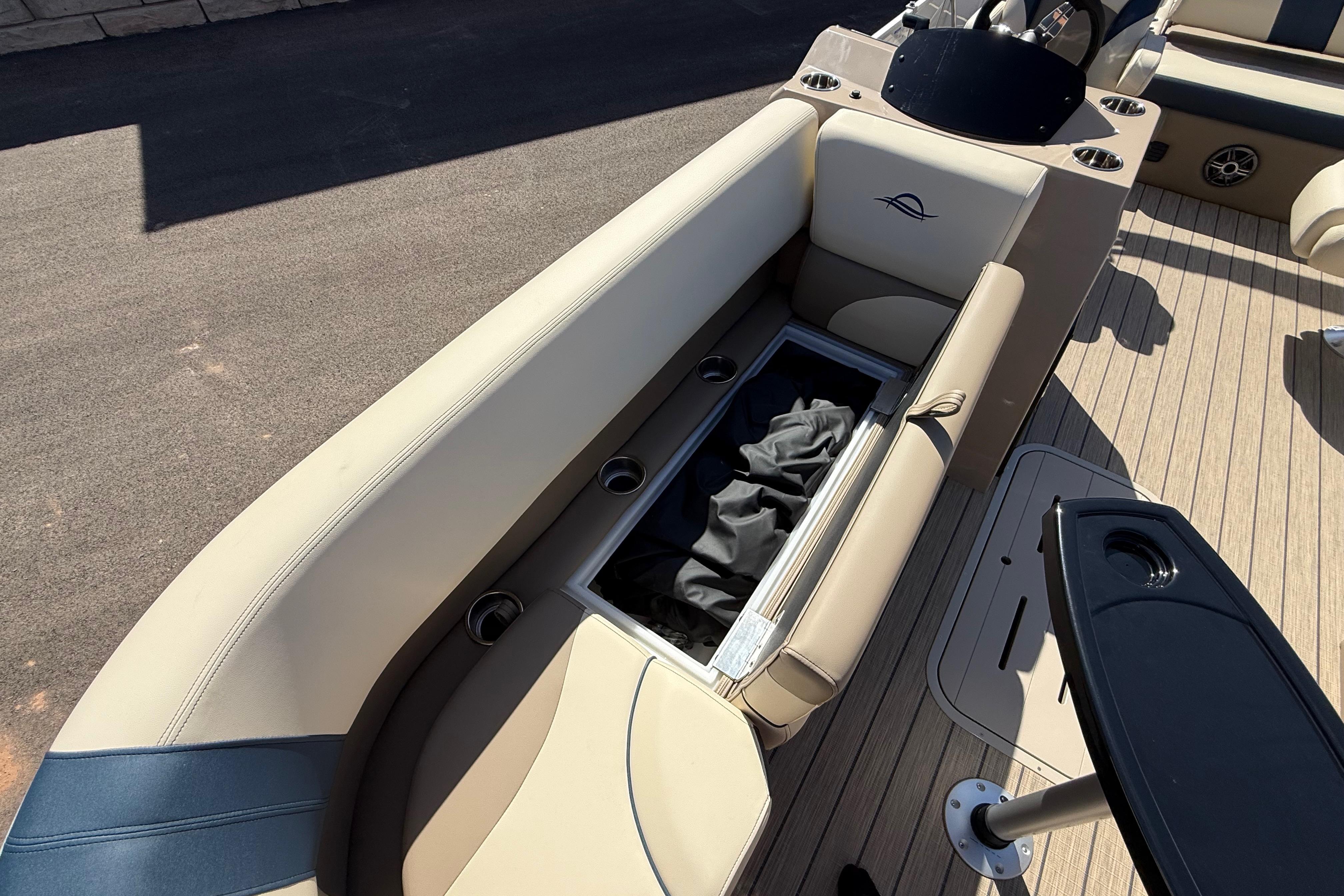 2026 SunCatcher Select 322SL boat interior with beige seating and storage compartment.
