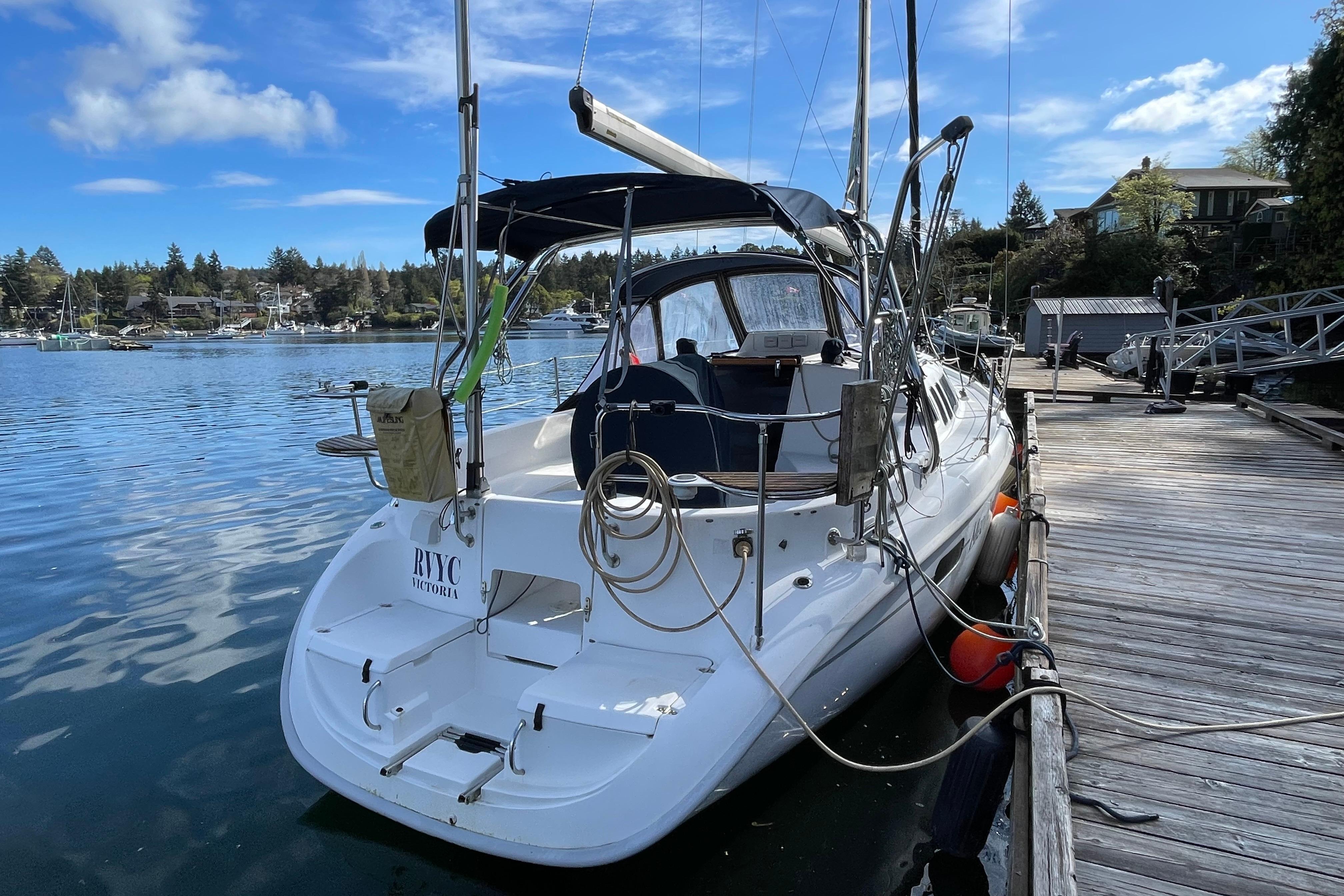 Hunter 340 sailboat from 2000 docked at a marina under a clear blue sky.