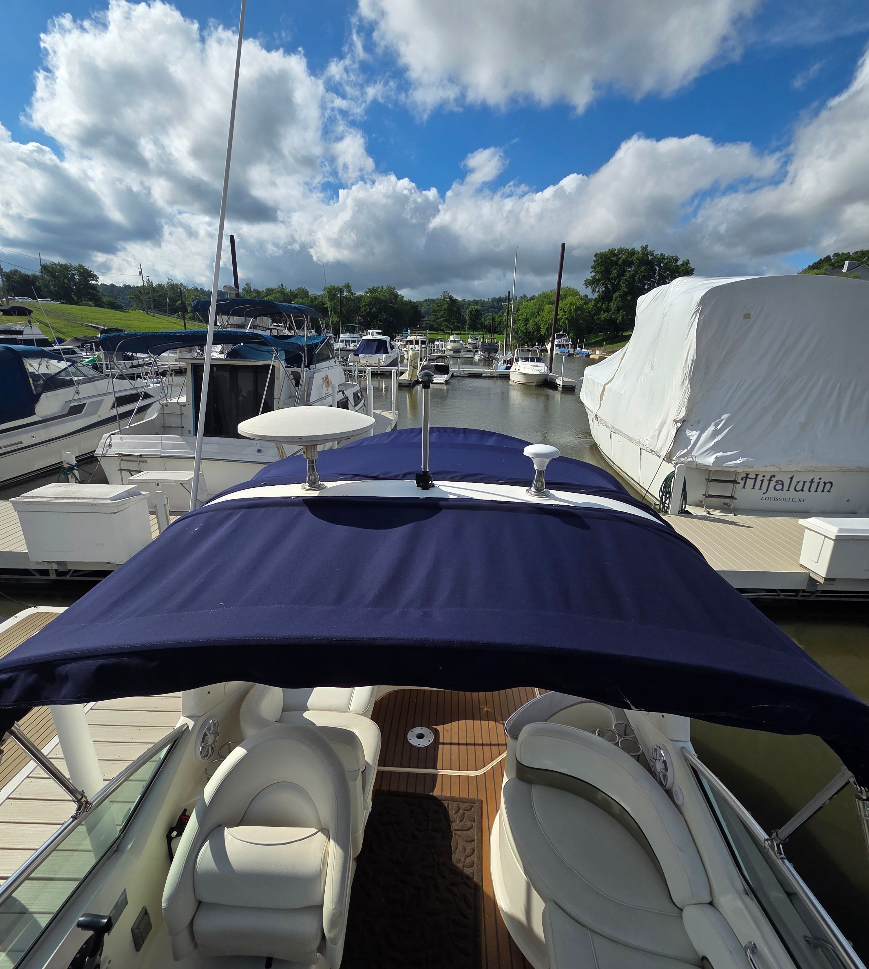 The image shows the cockpit of a Sea Ray Sundancer 260 in a marina.
