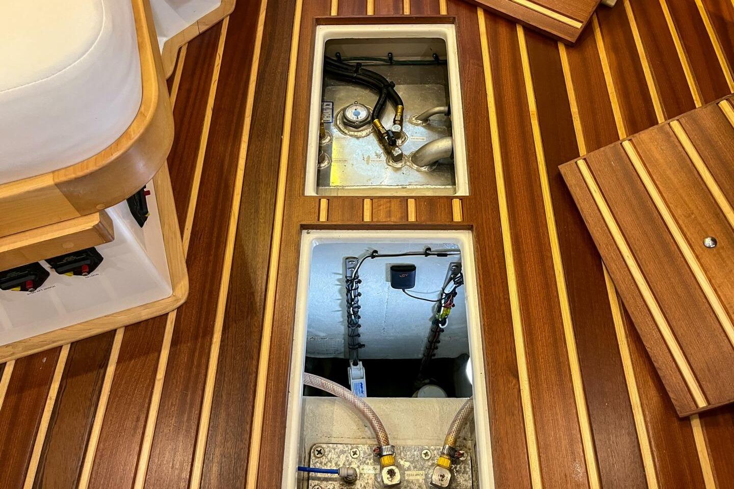 2023 Island Packet 439 yacht interior with open floor compartments, showcasing wooden finish.