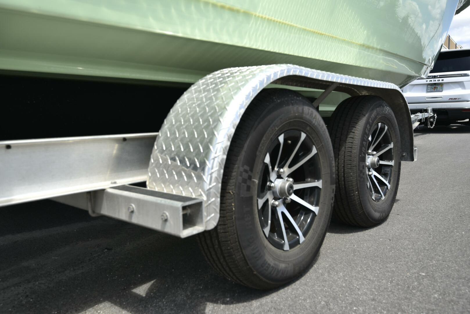 2023 Sea Pro 239 Deep V CC trailer with dual wheels and metallic fenders.