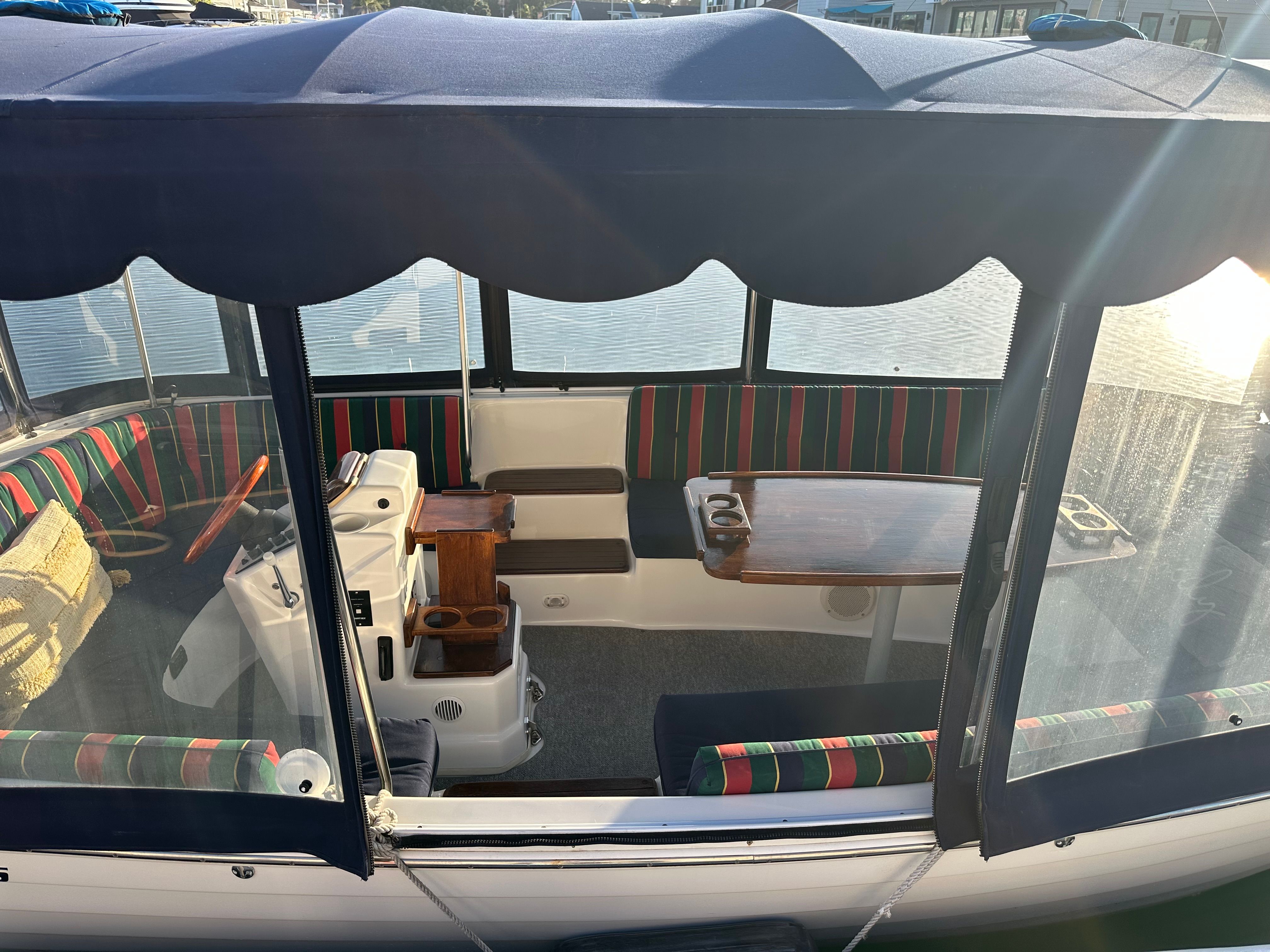Interior of a 2004 ElectraCraft 18LS with striped seating and a wooden table.