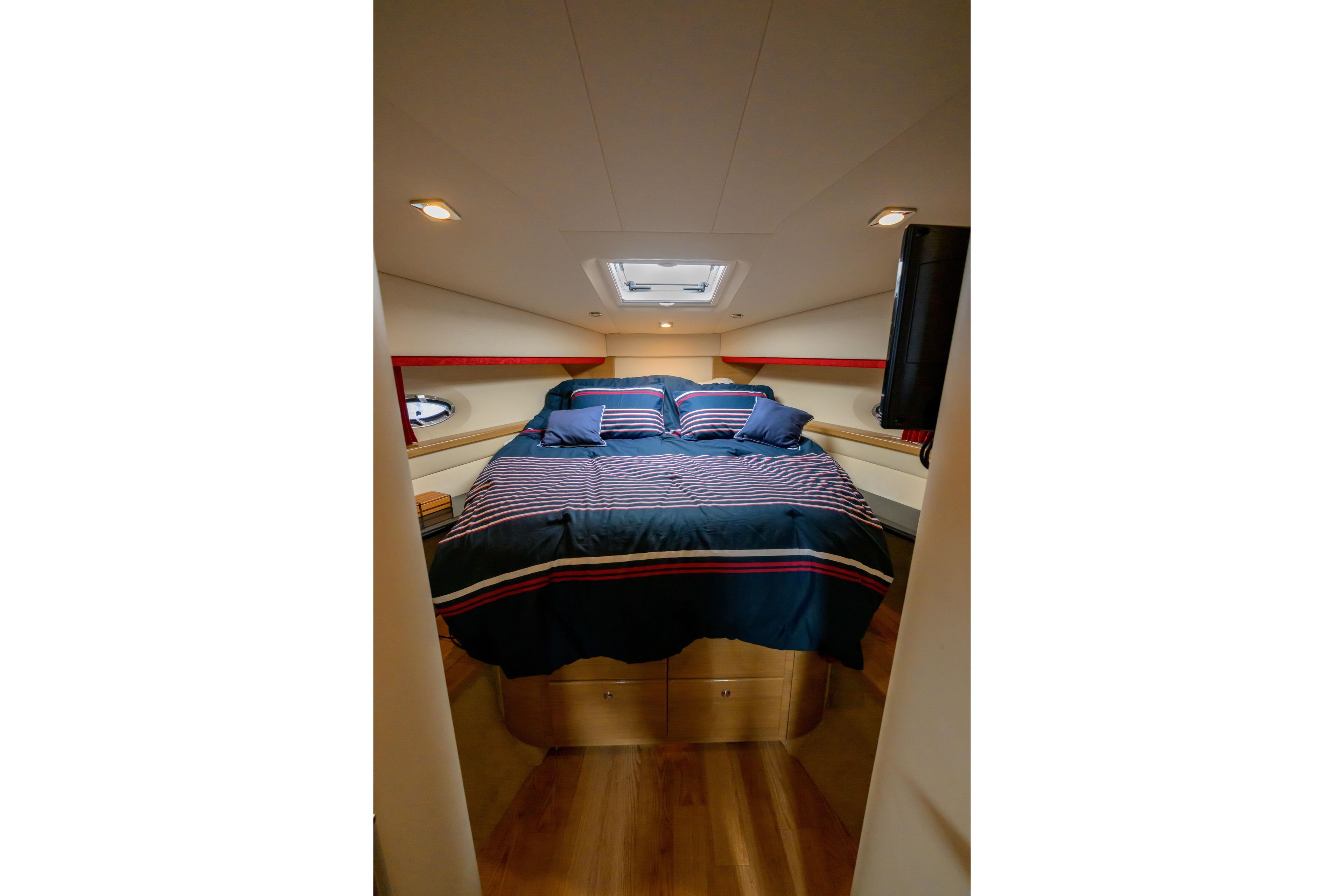 Luxurious bedroom interior of 2010 Formula 45 Yacht with striped bedding and modern lighting.