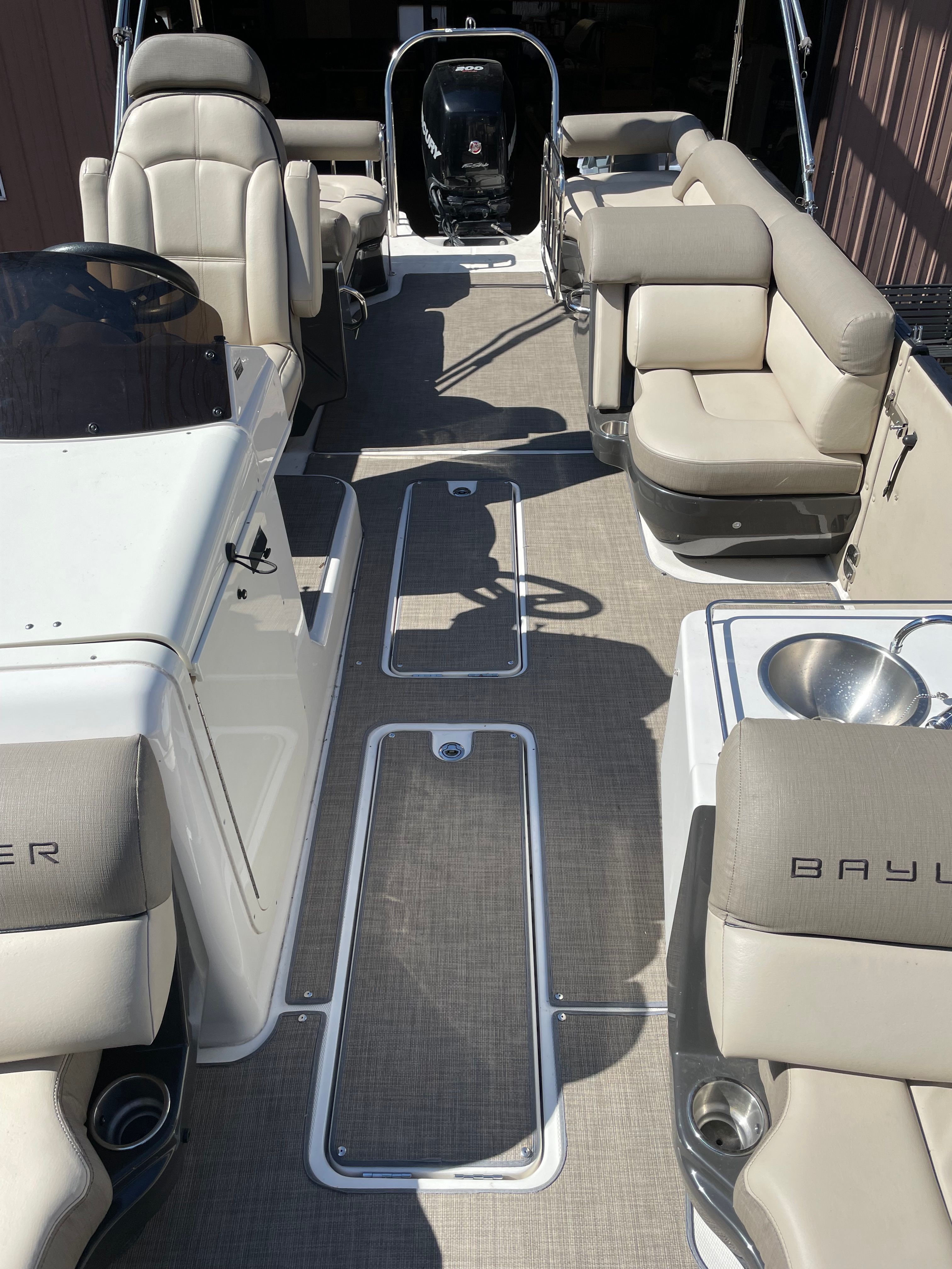 Interior view of a 2016 Bayliner Element XR7 with beige seating and gray flooring.