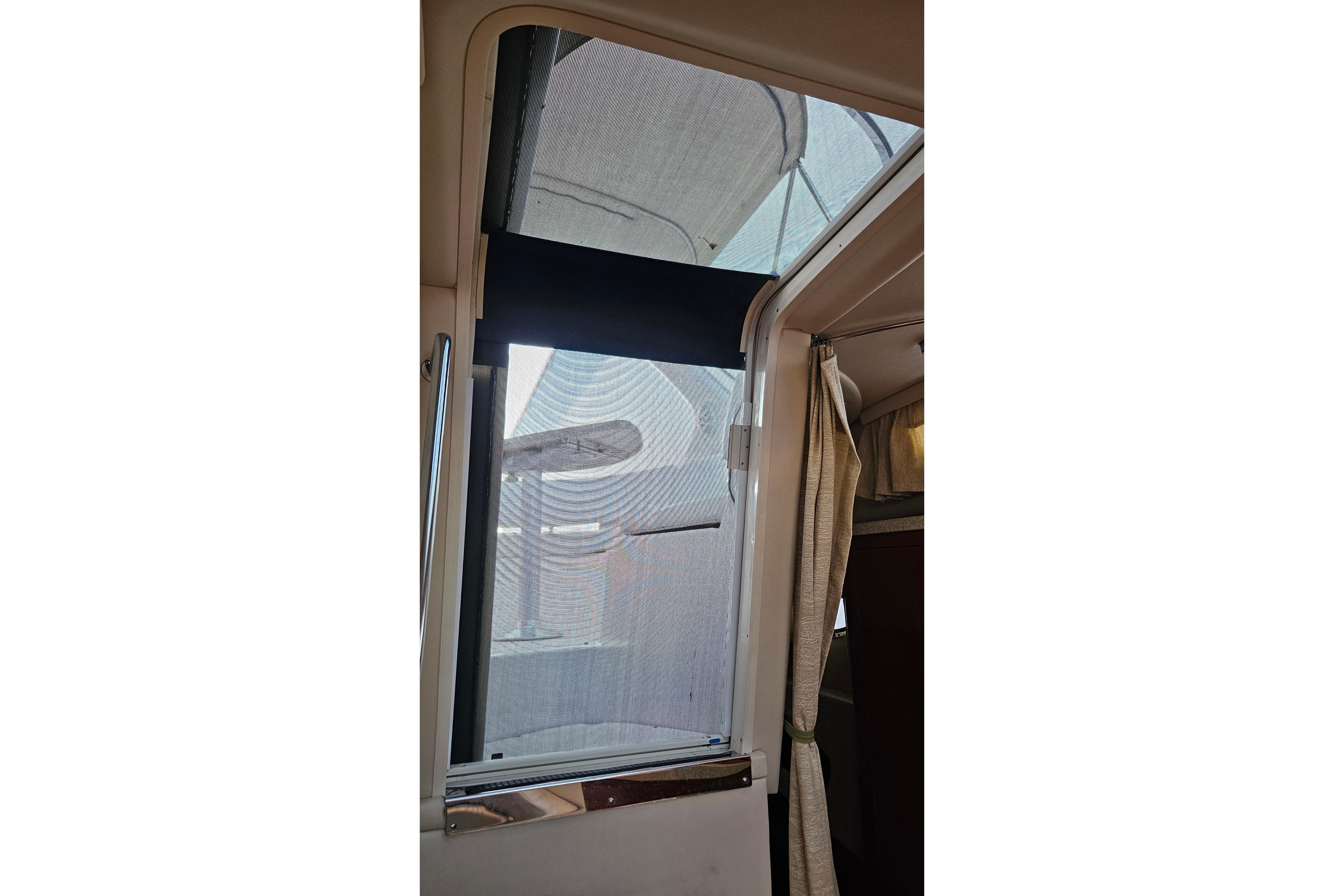 Interior view of 2005 Regal 3060 Window Express boat with open window and curtain.