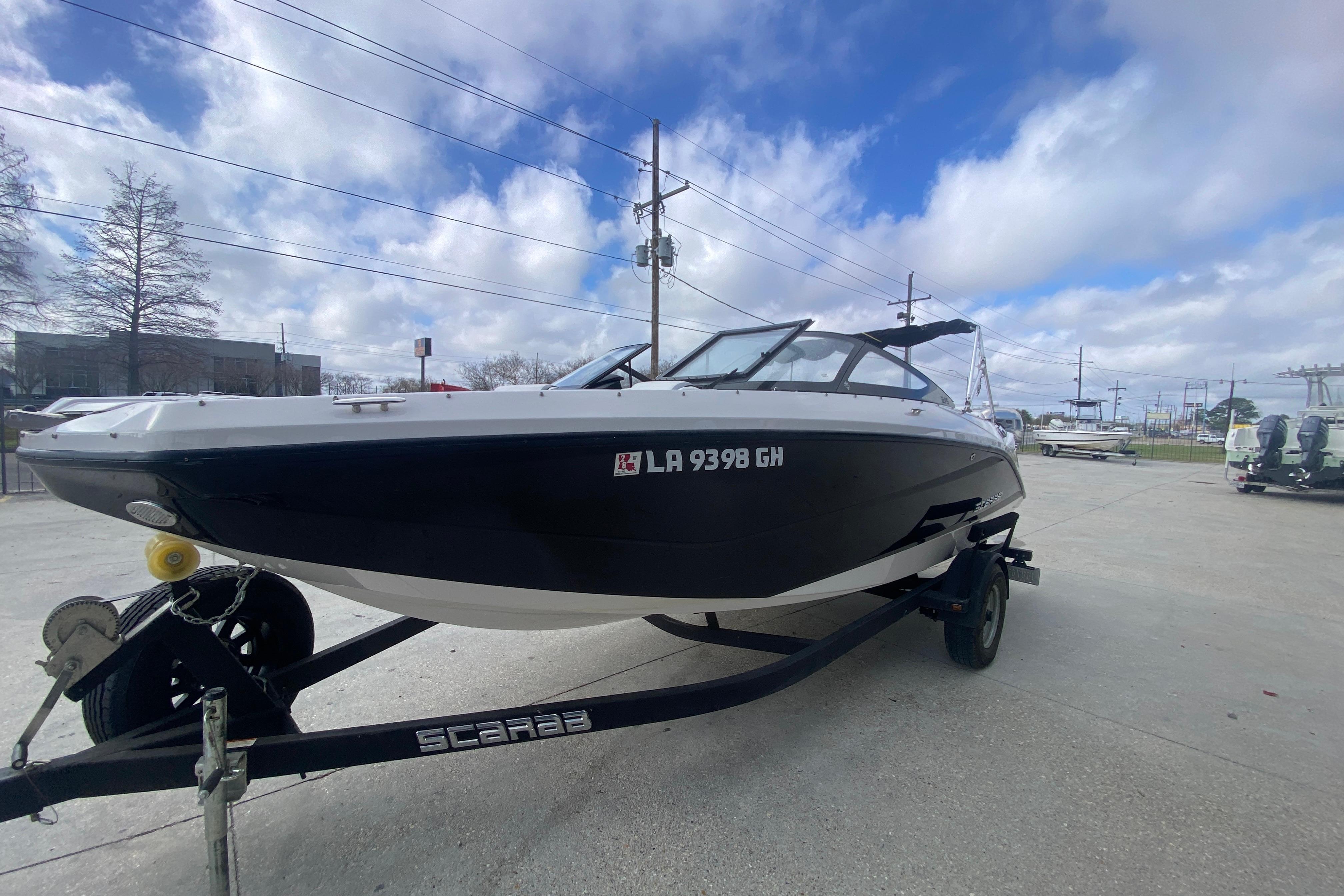 2018 Scarab 215 G boat on trailer under cloudy sky.