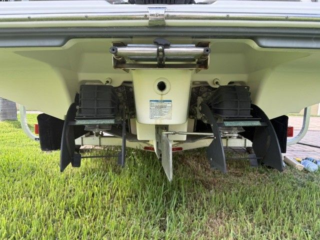 Rear view of a 2015 Yamaha Boats 242 Limited S on grass.