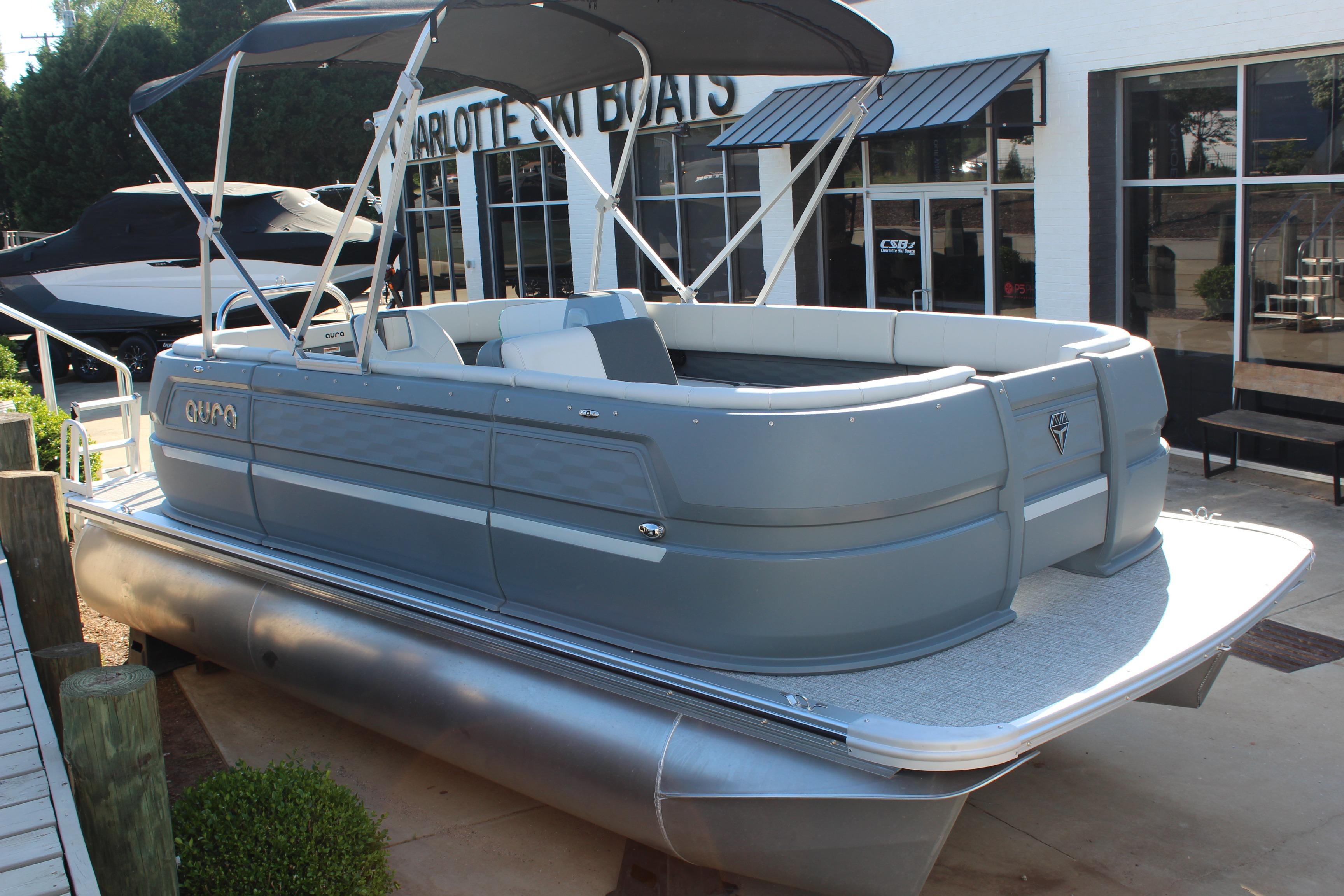 2026 Tahoe Pontoon Aura boat with canopy, docked near showroom.