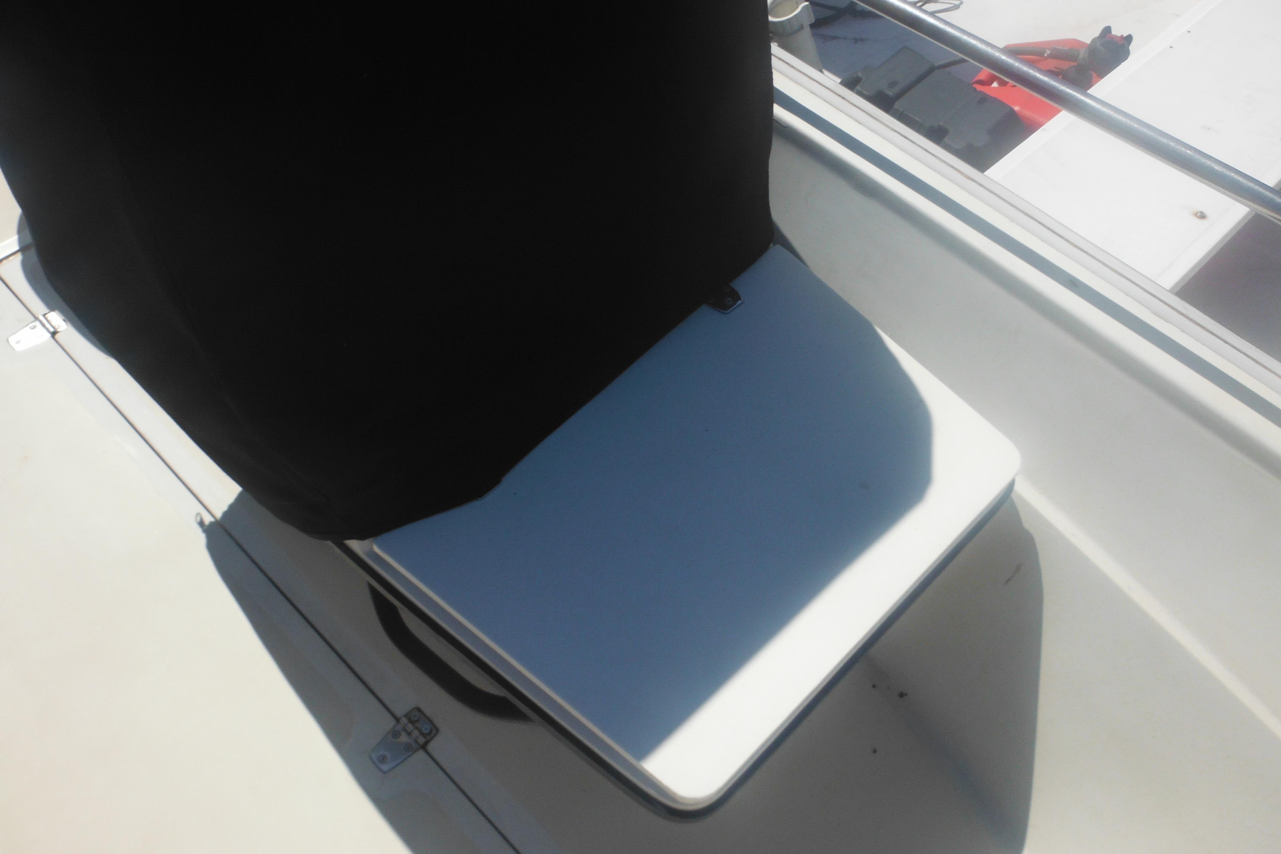 1991 Boston Whaler 16 SL boat seat with black cover and white base.