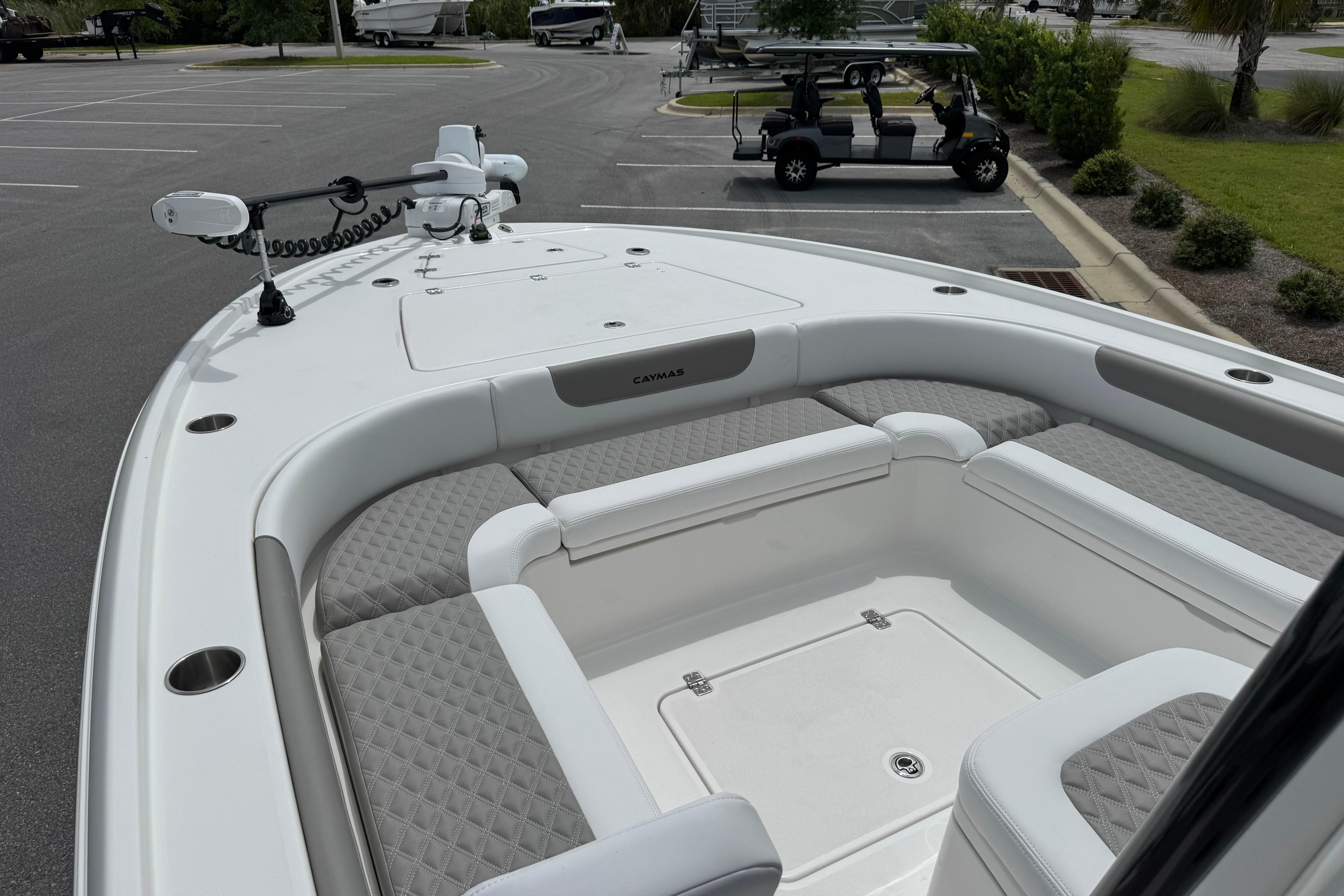 2027 Caymas 26 HB boat interior with cushioned seating and modern design in a parking lot.