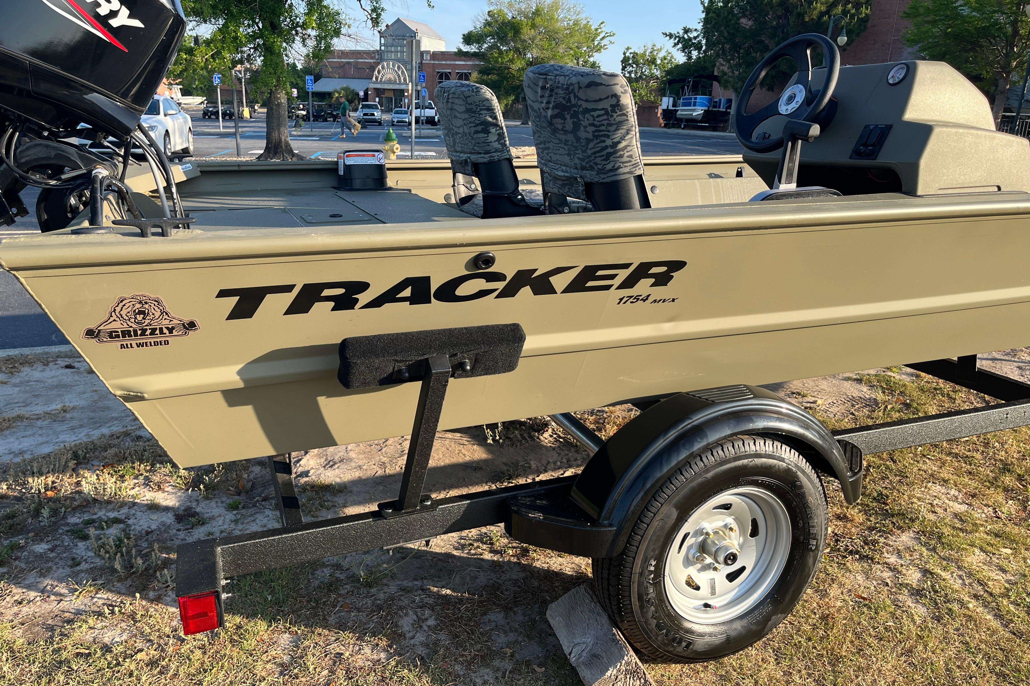 2026 Tracker Grizzly 1754 SC boat on trailer, parked outdoors in a sunny setting.