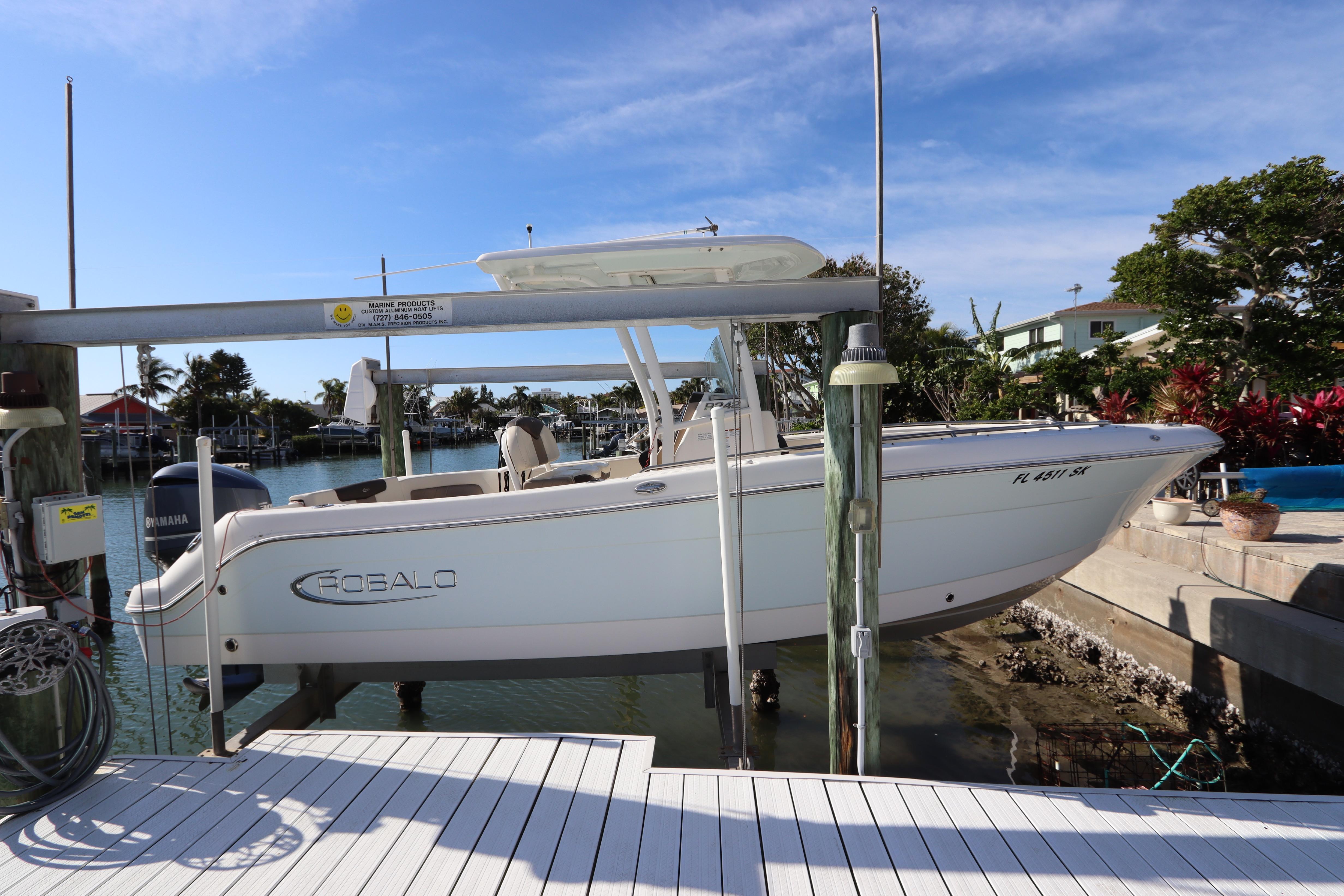 2019 Robalo R242 Center Console boat docked by waterfront homes.