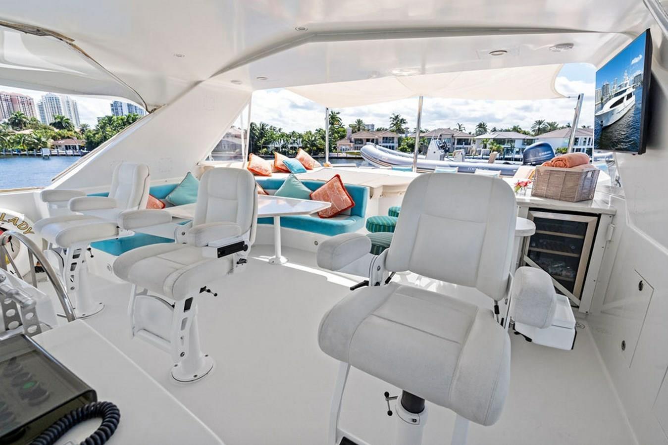 Luxurious 2001 West Bay Sonship yacht interior with white seating and waterfront view.