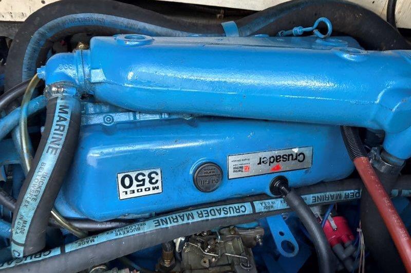 Engine of 1987 Tollycraft 34 Sundeck Motor Yacht, Crusader Model 350, blue with marine hoses.