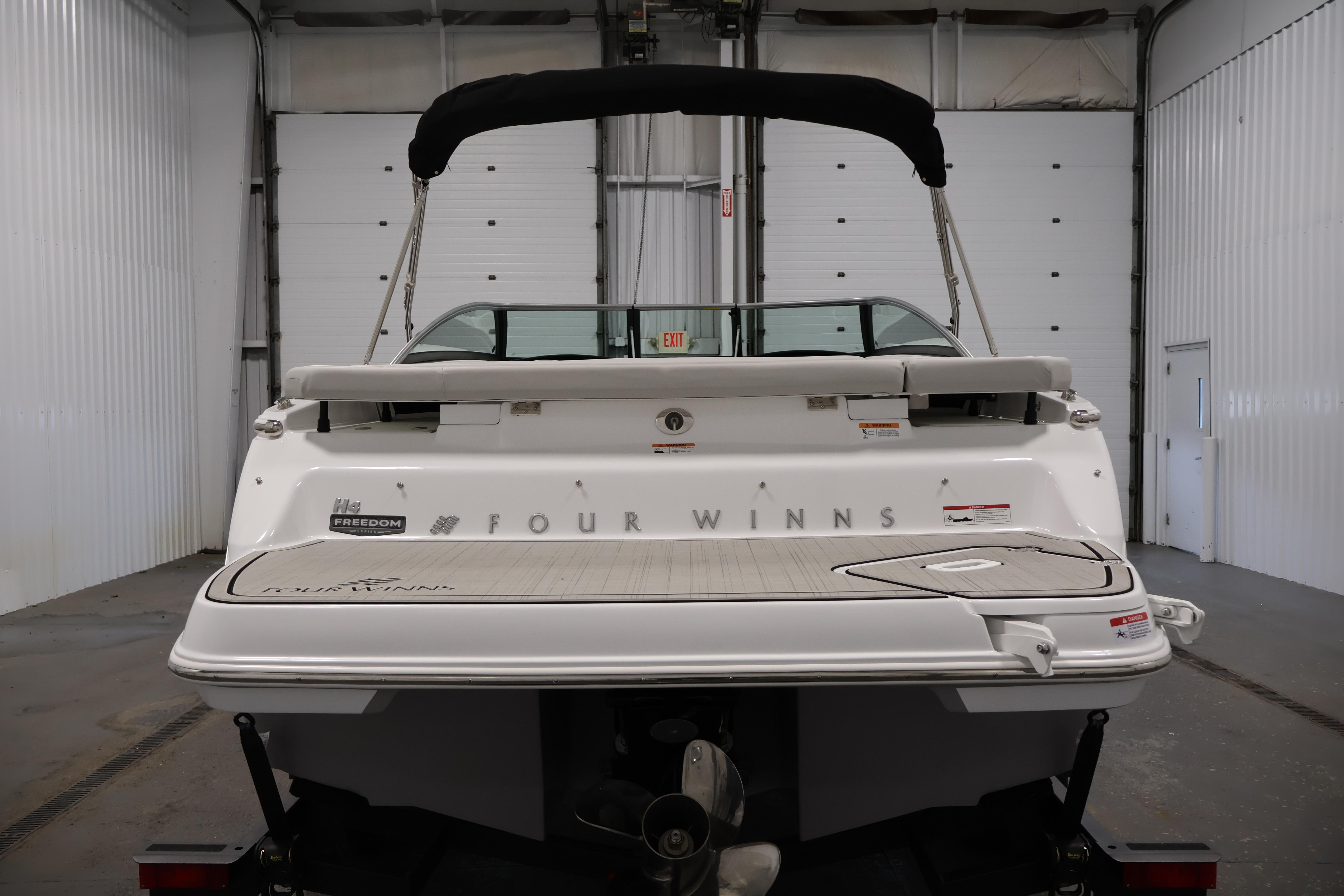 2026 Four Winns H4 Freedom boat in a garage, rear view.