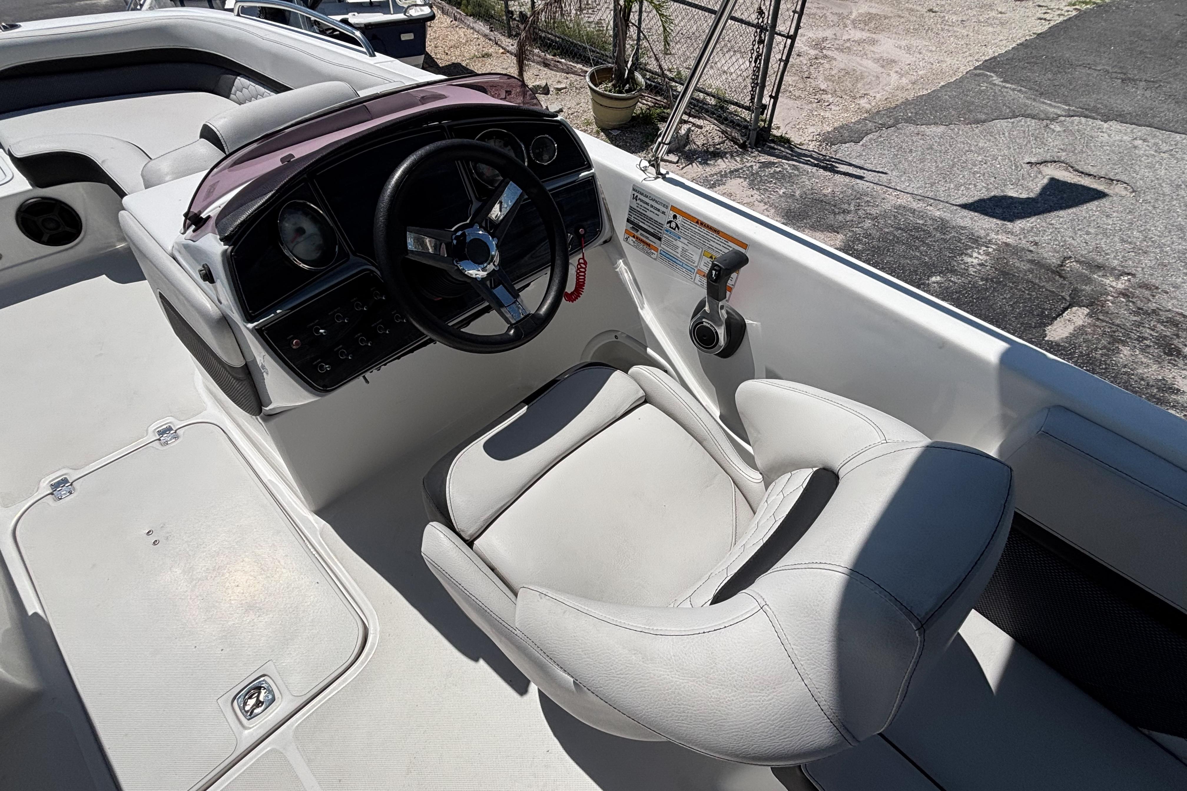2019 Hurricane Sundeck Sport 218 OB boat cockpit with steering wheel and seating.