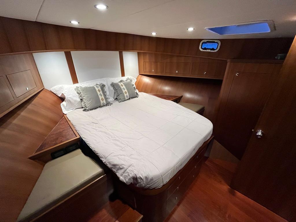 Luxurious cabin interior of 2025 Bracewell 41 yacht with cozy bed and wooden finish.