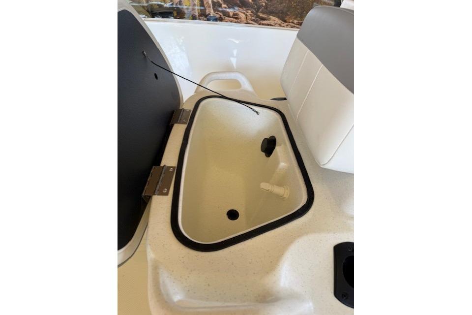 2026 Mako Pro Skiff 17 CC boat interior storage compartment with open lid.
