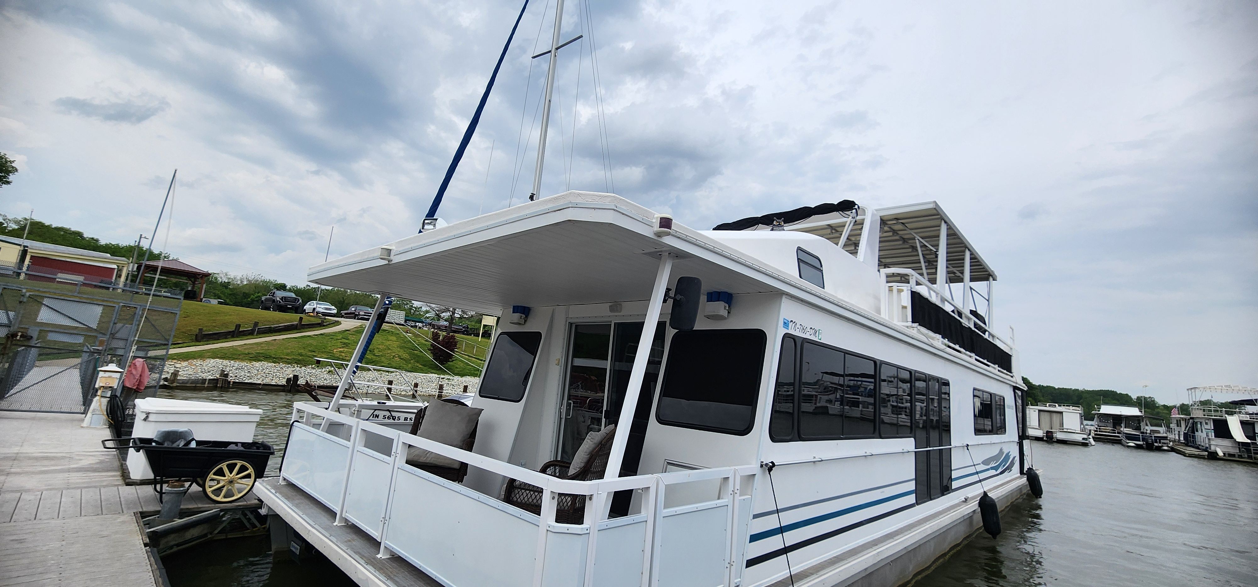 A 2003 Destination Yachts houseboat docked, featuring a spacious upper deck.