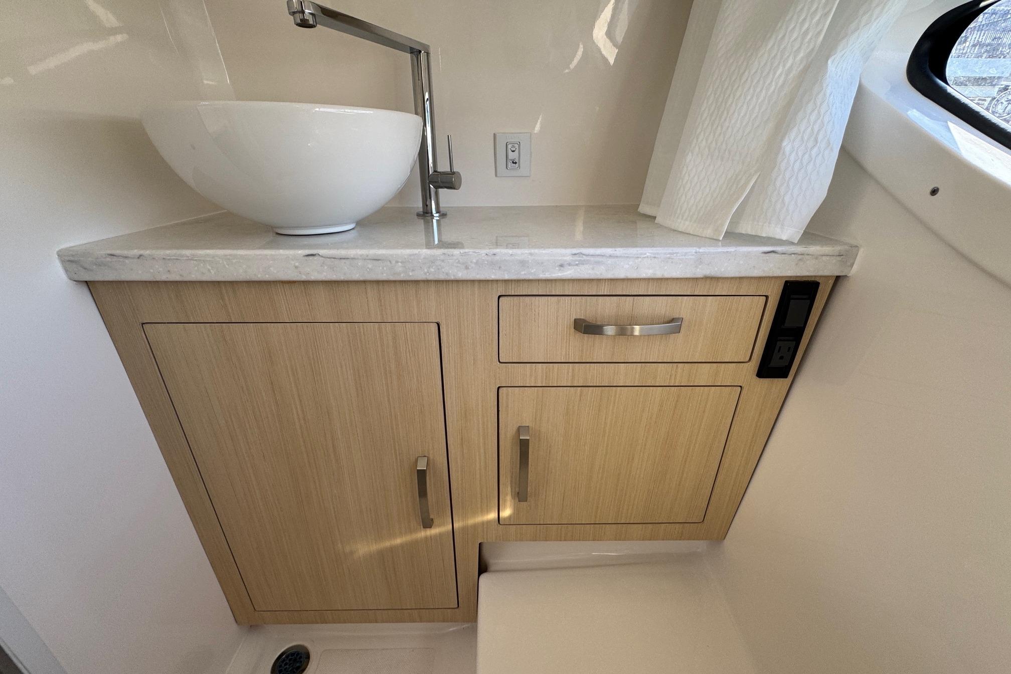 Modern bathroom vanity in 2026 Regal 33 XO boat with vessel sink and wood cabinetry.