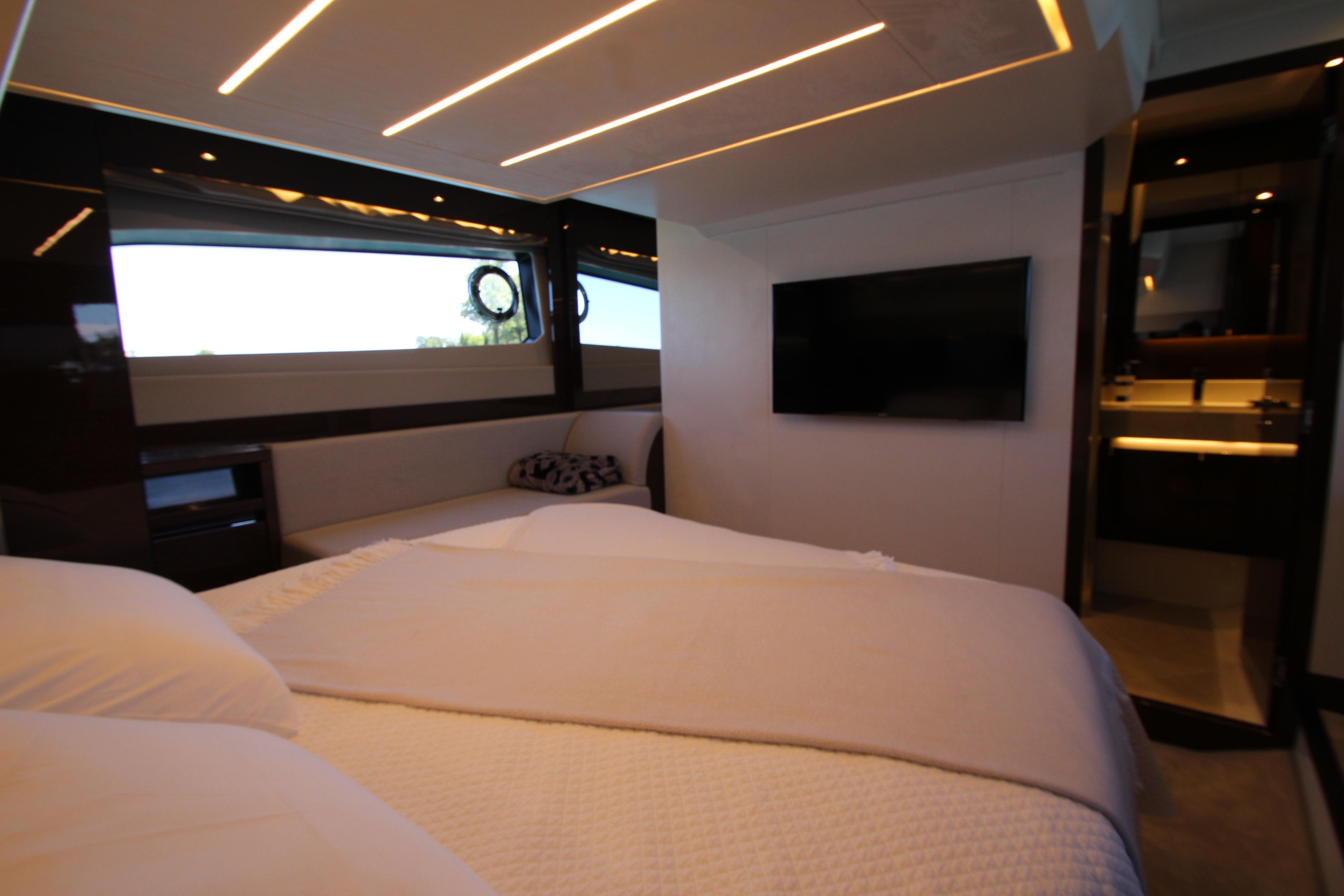 Luxurious interior of 2022 Prestige 520 yacht bedroom with modern design and ambient lighting.