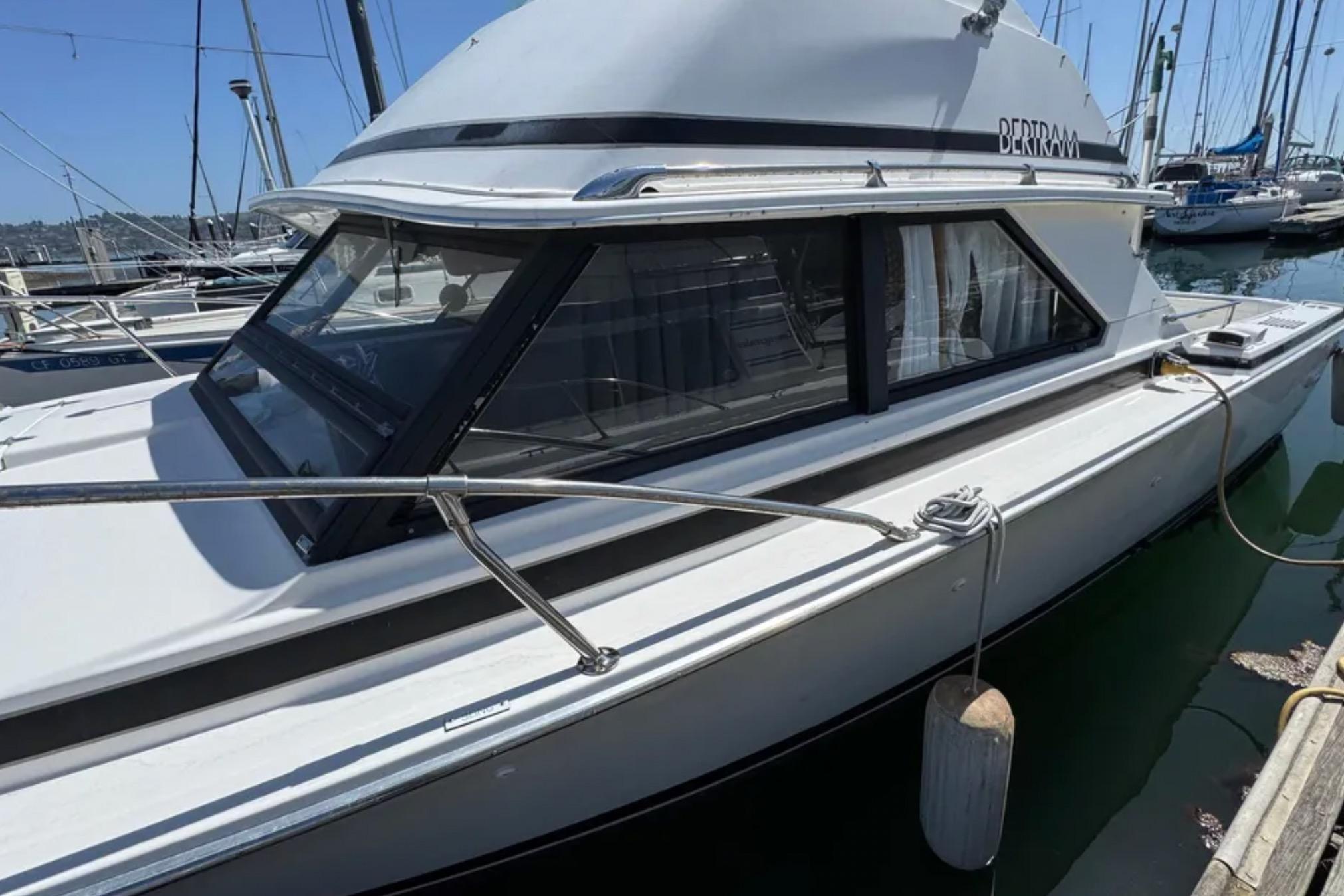 1988 Bertram 28 Sport Fisherman boat docked at marina, side view.